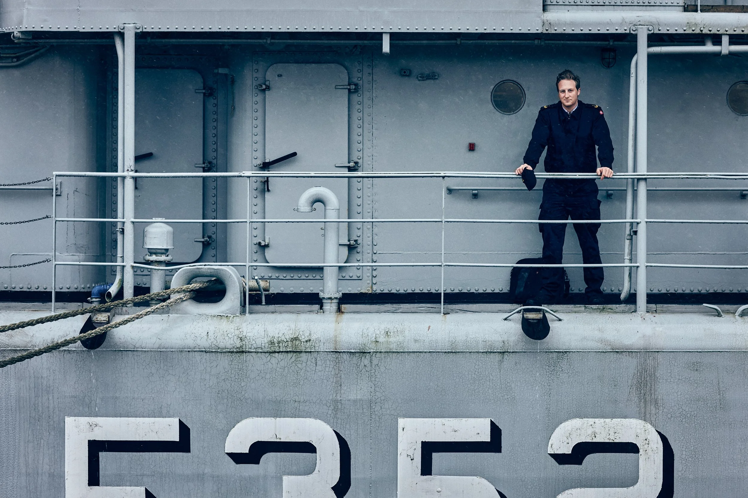 Soldier standing on naval ship deck leaning on railing
