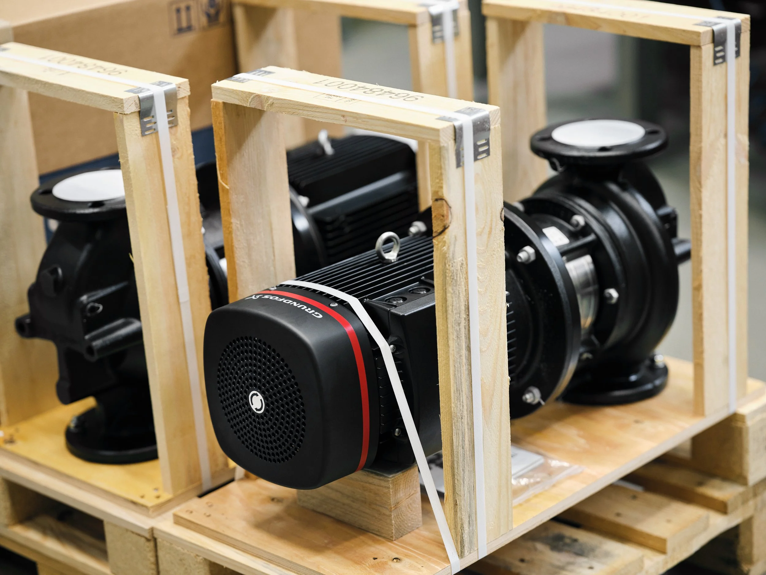 Grundfos pump secured in wooden transport frame on pallet, ready for shipment