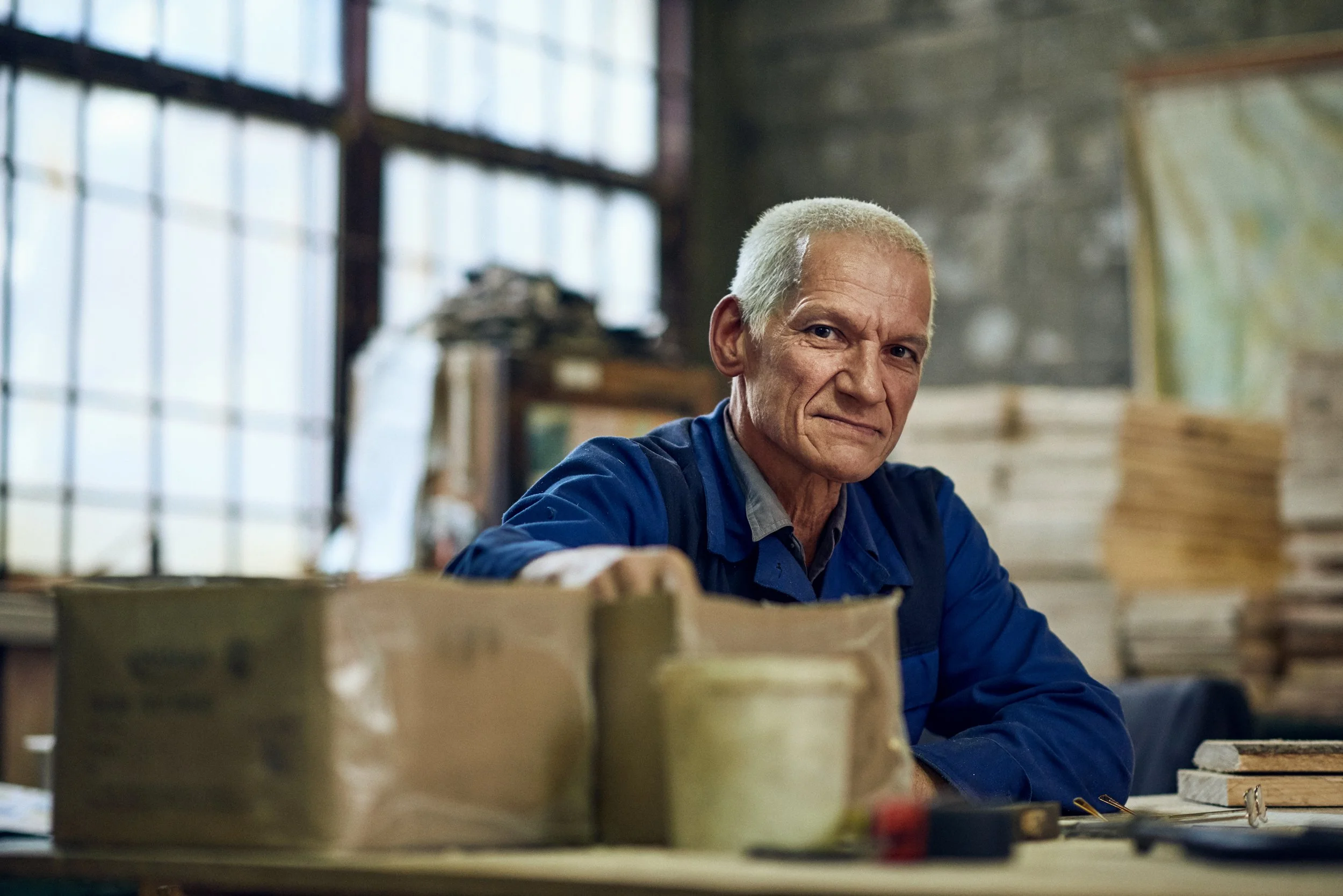 
Portrait of older man in workshop surrounded by materials, work environment context