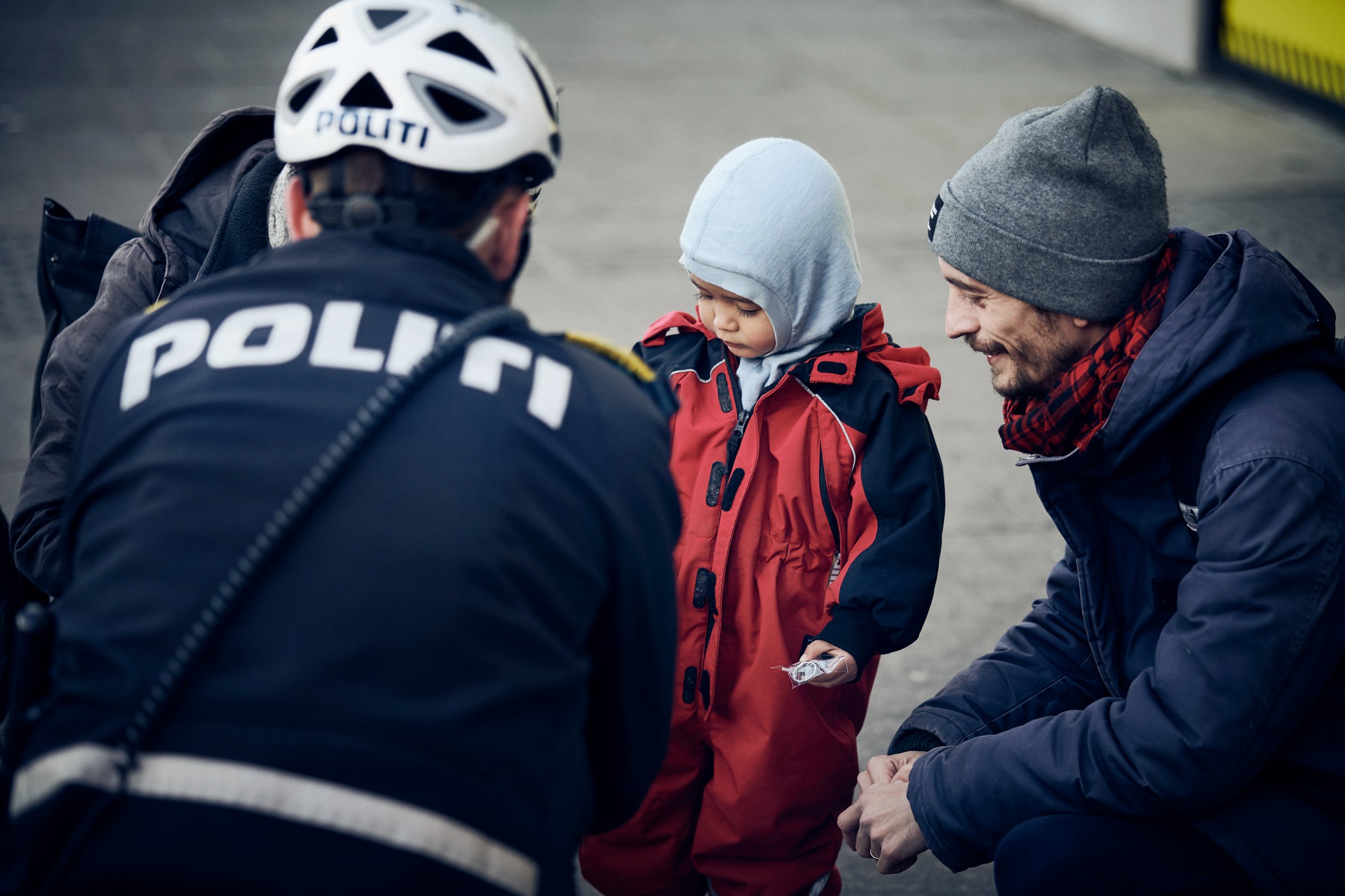 Police officer interacting with child and adult outdoors