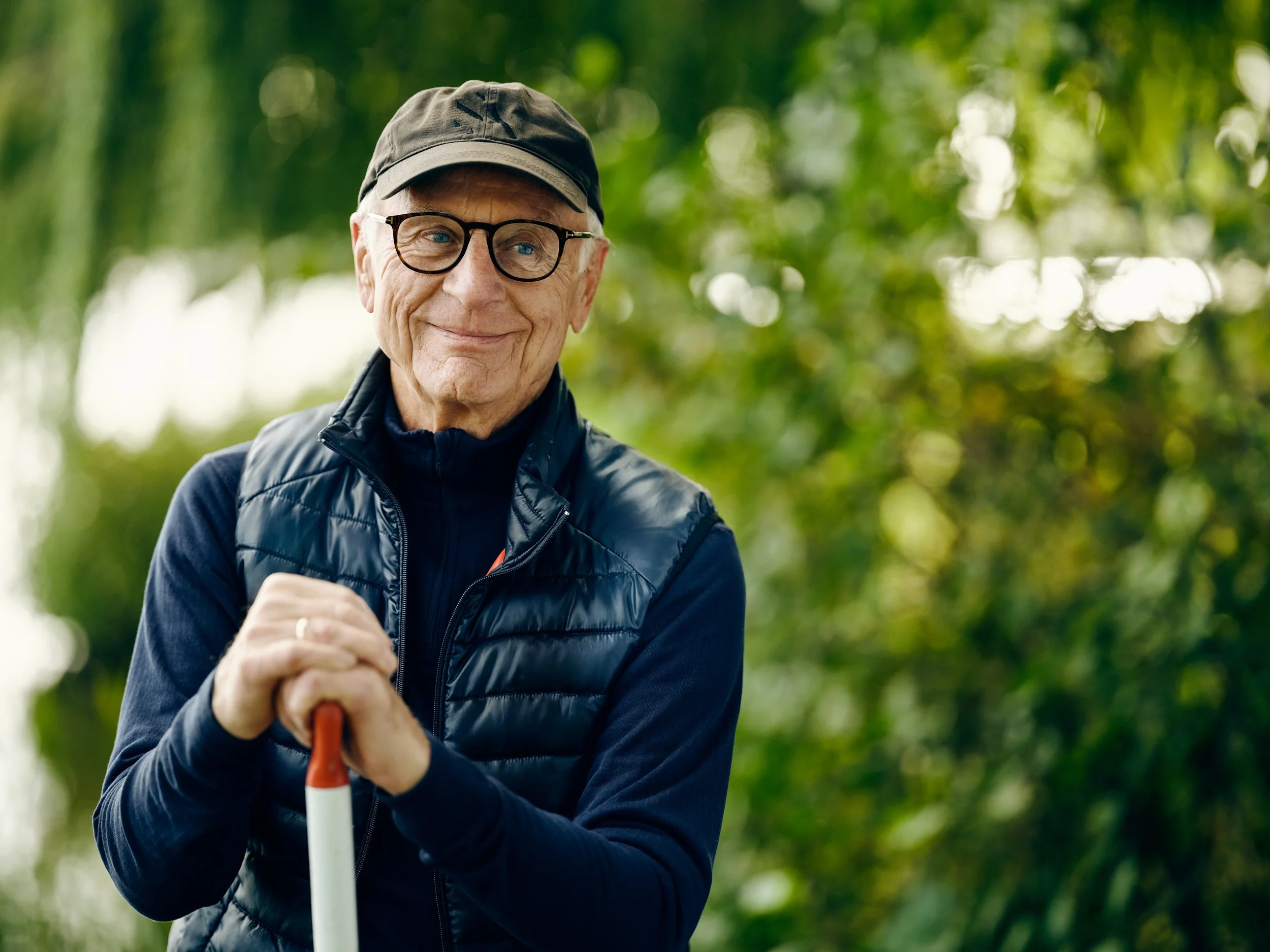 Older man standing outdoors with paddle, active lifestyle portrait