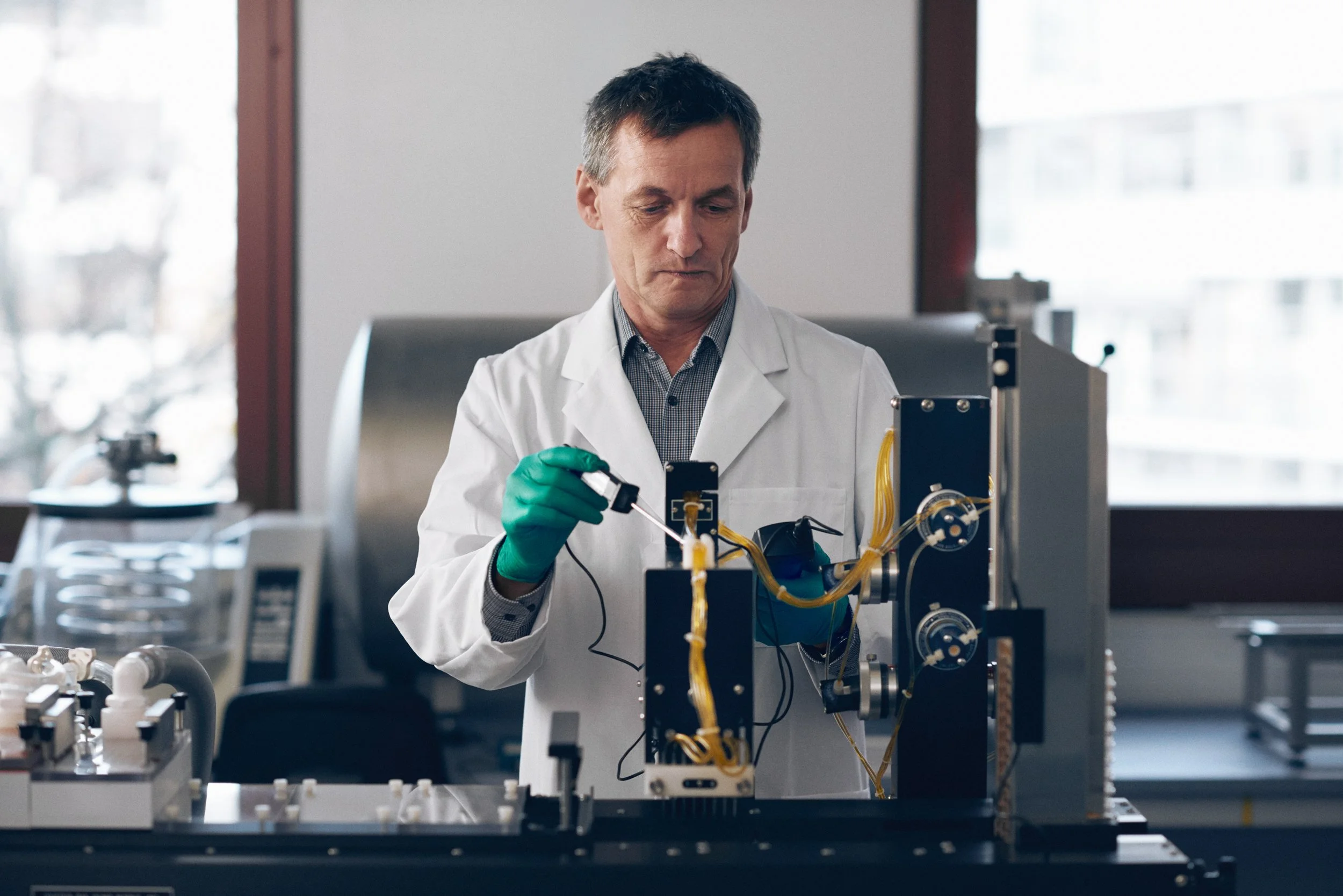 Researcher working with laboratory instrumentation, adjusting setup during testing process