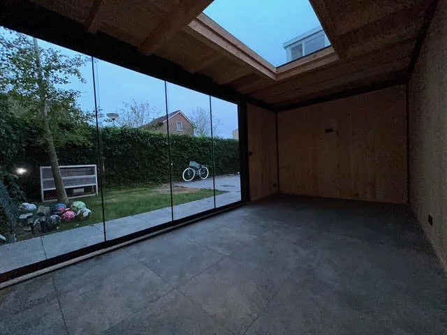 Een foto van een tuinhuisje met een glazen deur