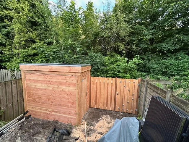 Een foto van een tuinhuisje en een schutting