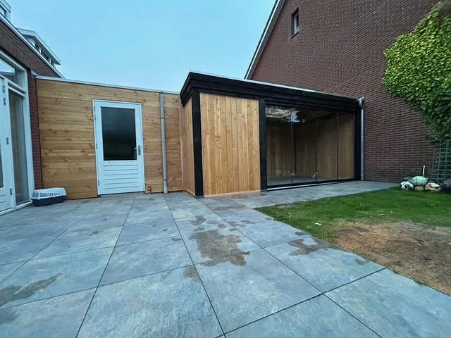 Een foto van een tuinhuisje met een glazen deur