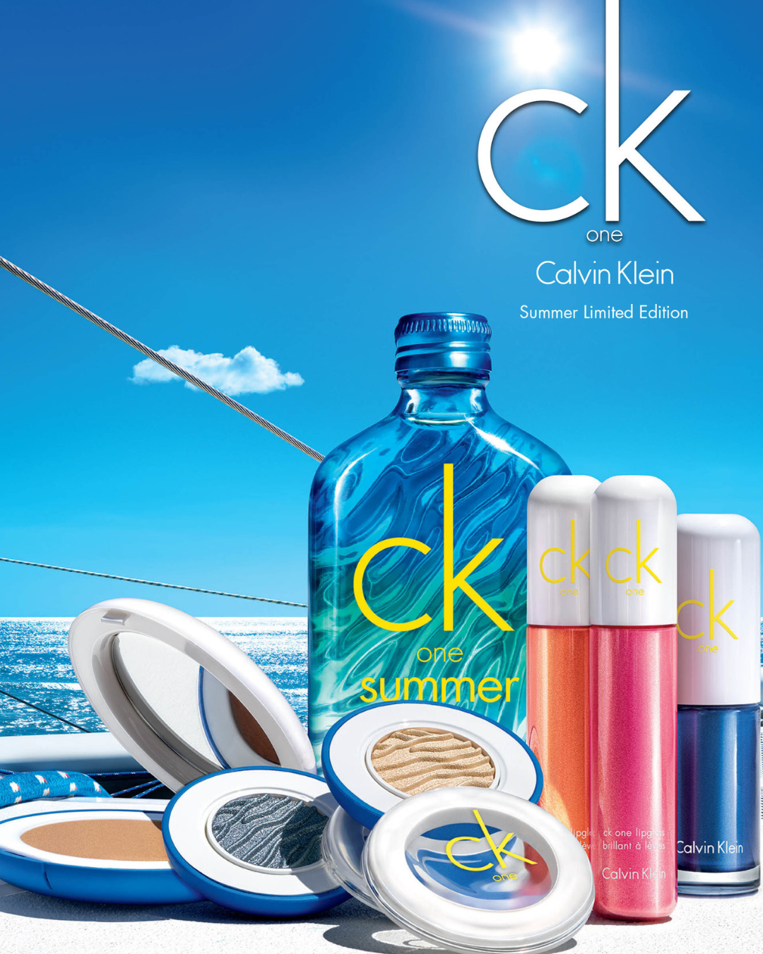 Calvin Klein CK One Summer Limited Edition fragrance collection with lip glosses and compacts, set against a bright, summery background featuring the ocean and sky.