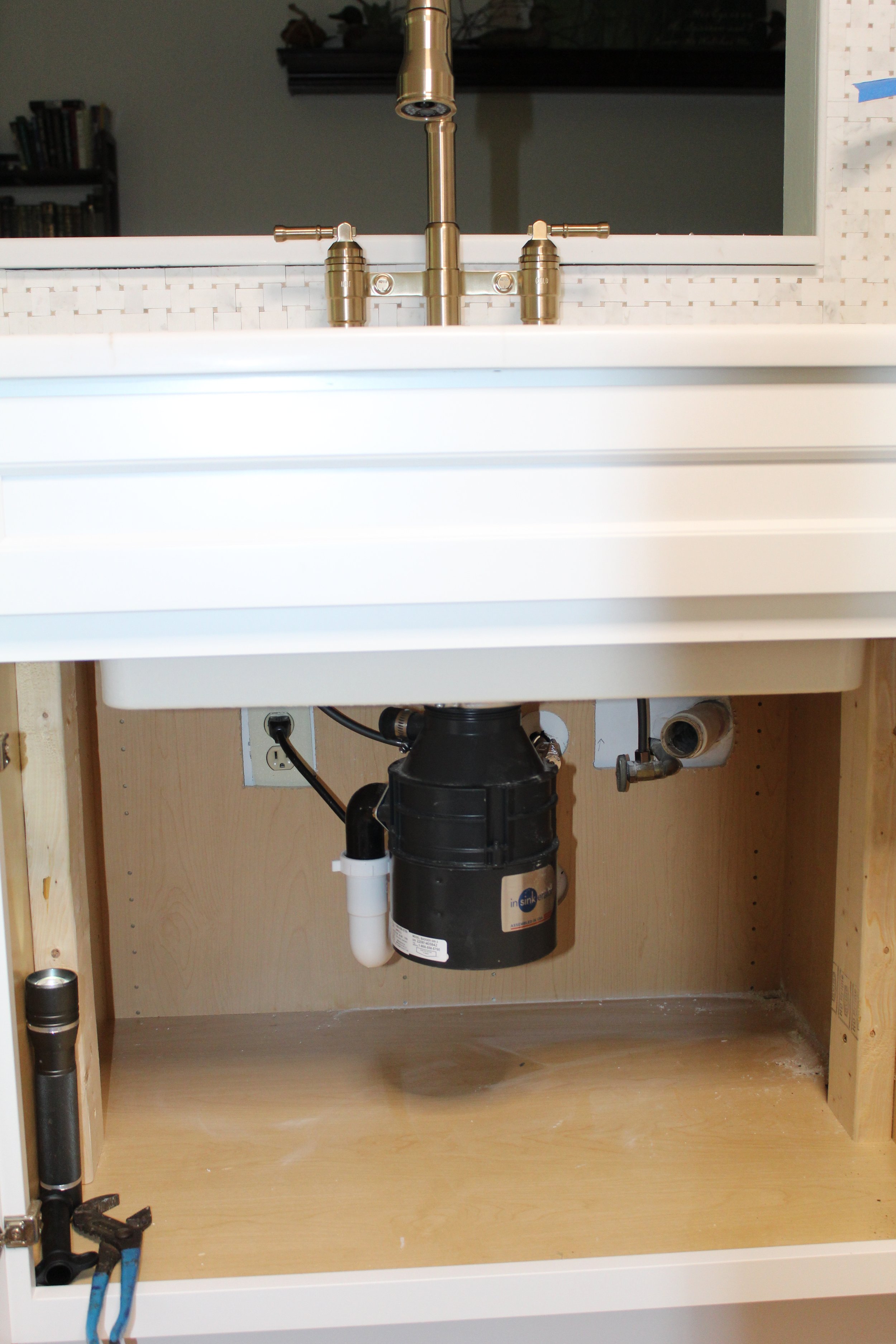 Under-sink plumbing and garbage disposal system installed by DC Dedicated Plumbing.