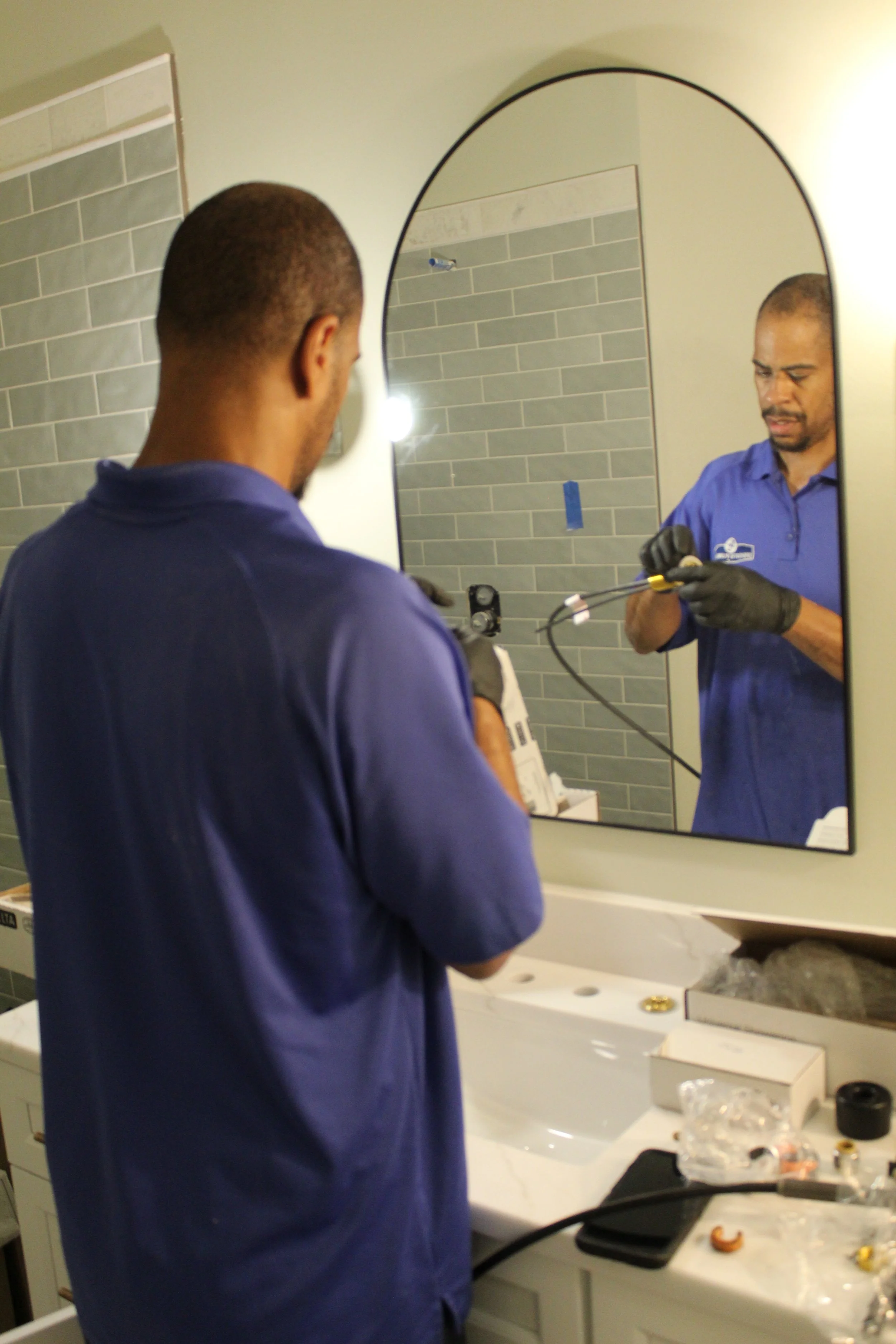 DC Dedicated Plumbing technician performing bathroom plumbing work.