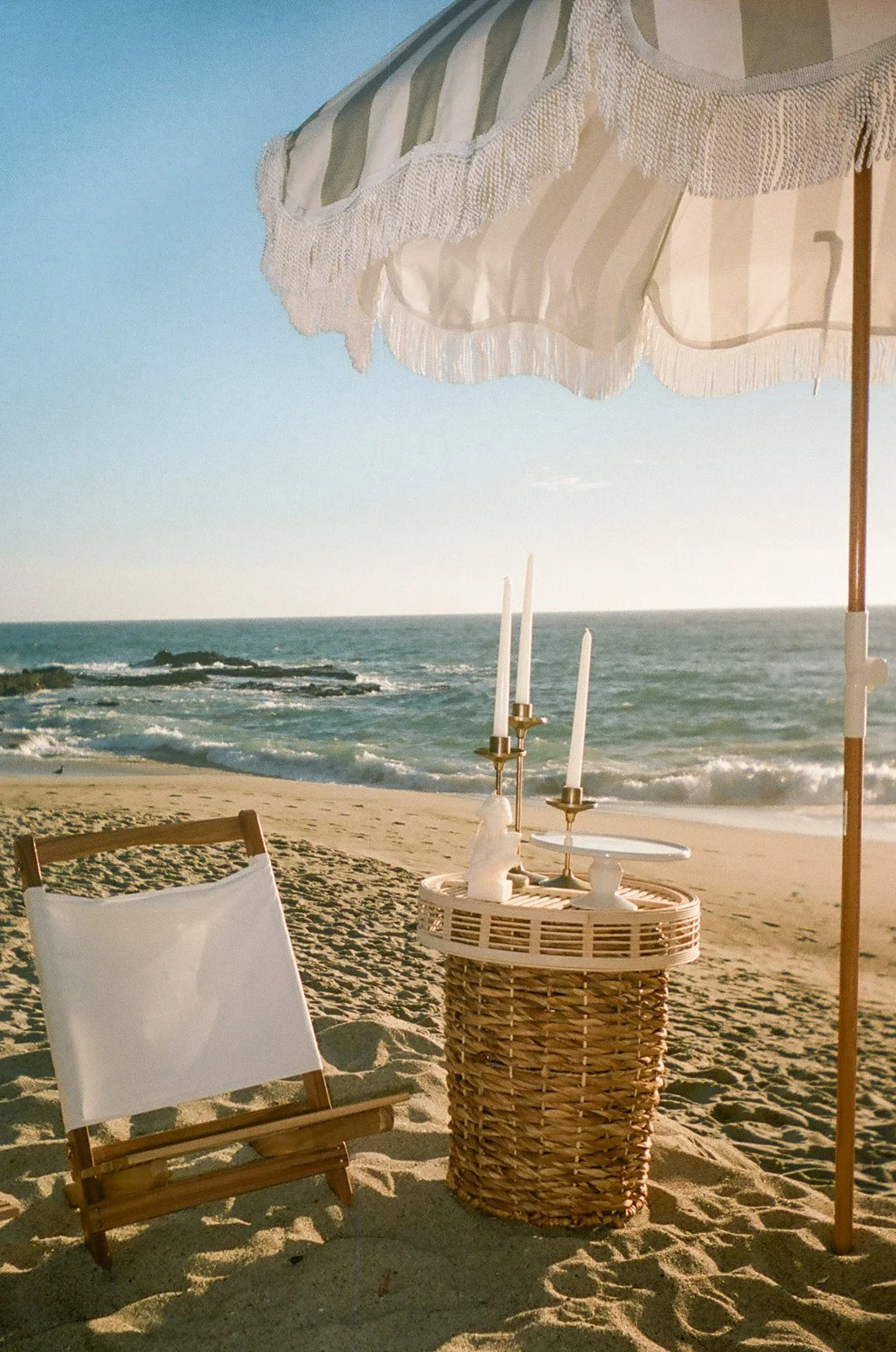 Beach setup with white beach chair and umbrella