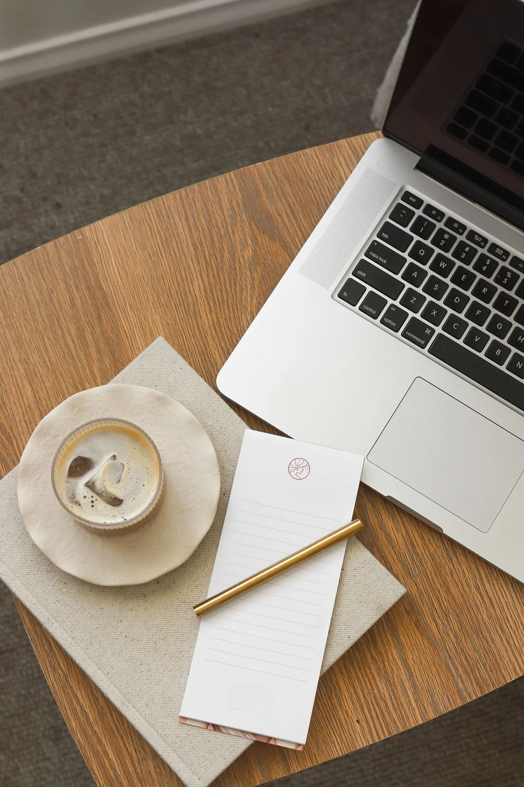 View of laptop and coffee with pen and notebook