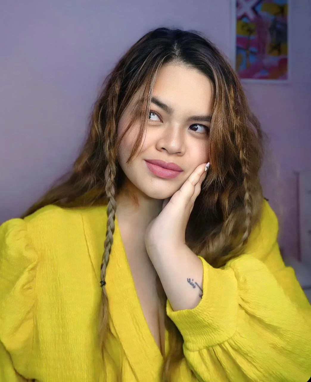 Woman wearing a bright yellow shirt and braids