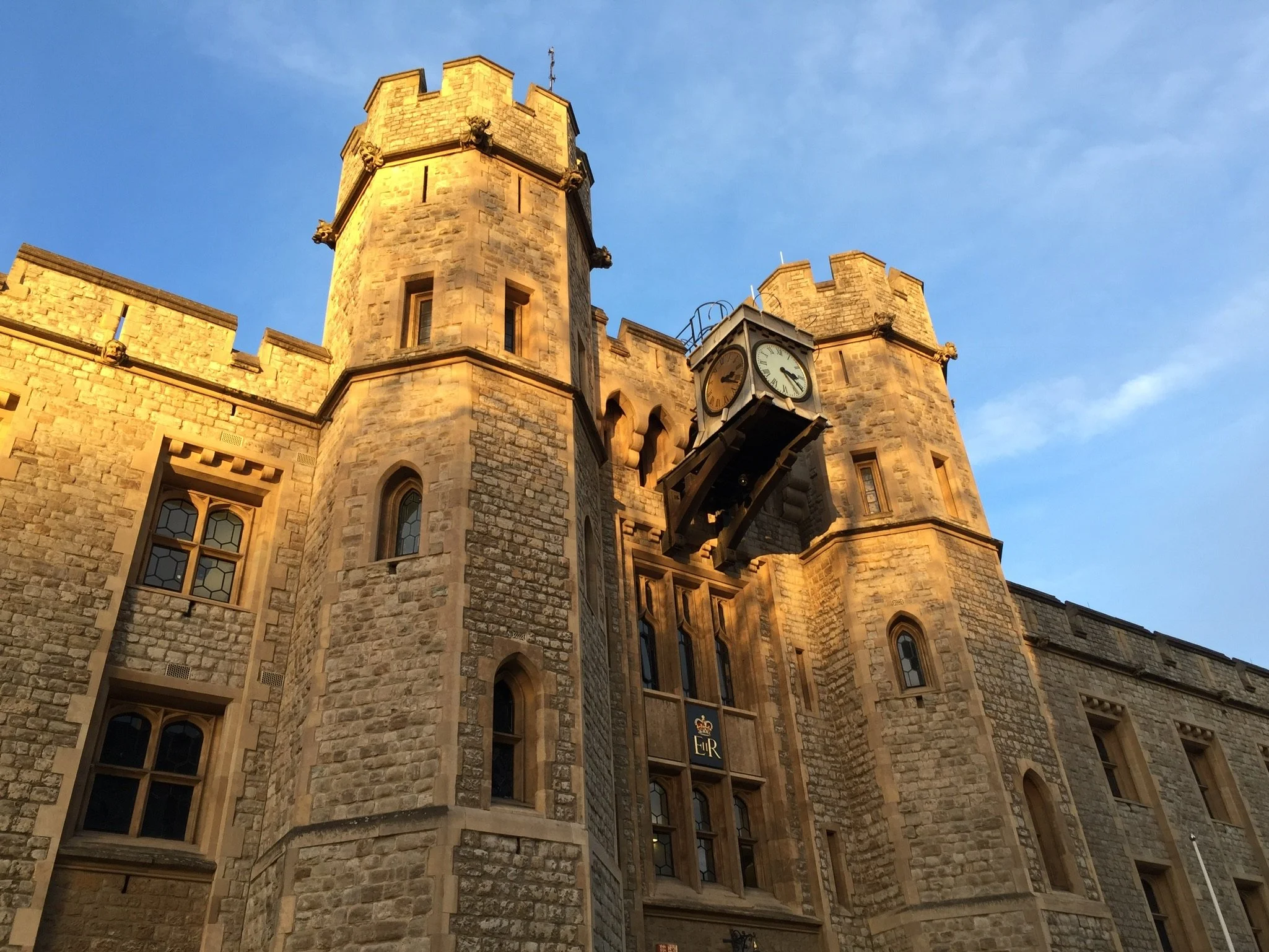 Stone castle with a clock tower and blue sky.