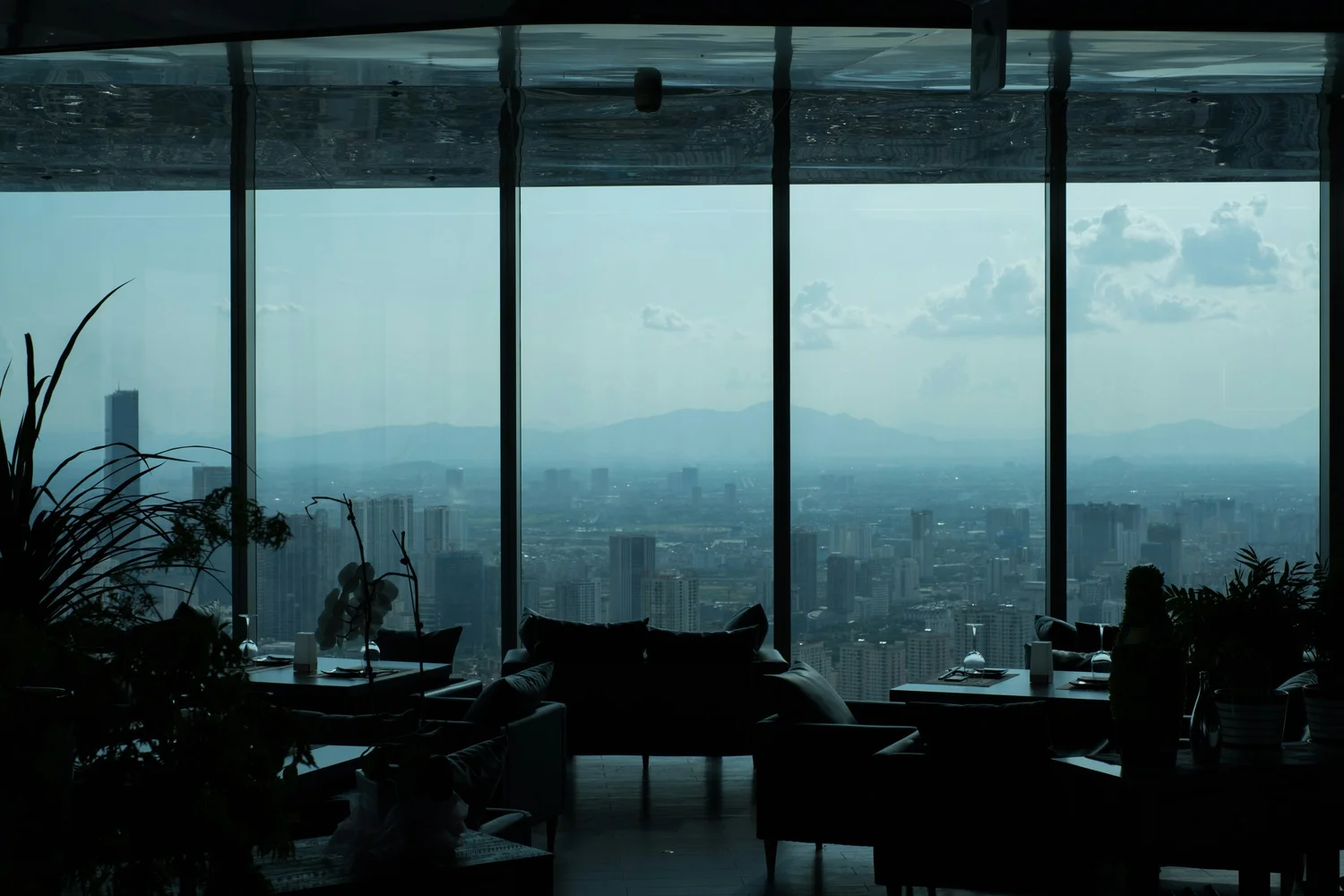 A refined lounge with floor-to-ceiling windows overlooking a city skyline