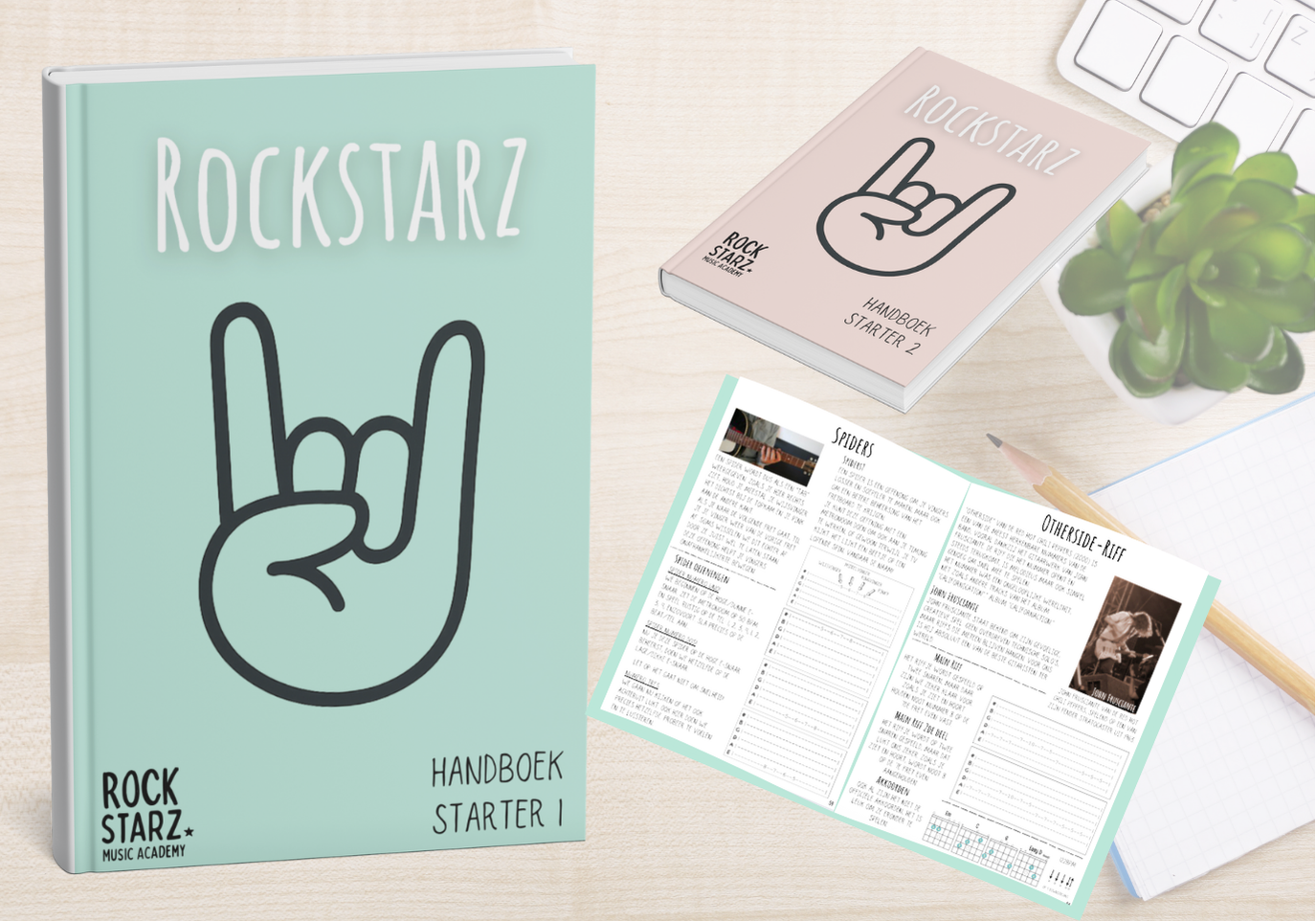 Music-themed study materials including a large turquoise handbook and a smaller pink handbook with a hand making the rock sign, an open sheet with notes and instructions, a pencil, a succulent plant, and a partial white keyboard on a light wood surface.