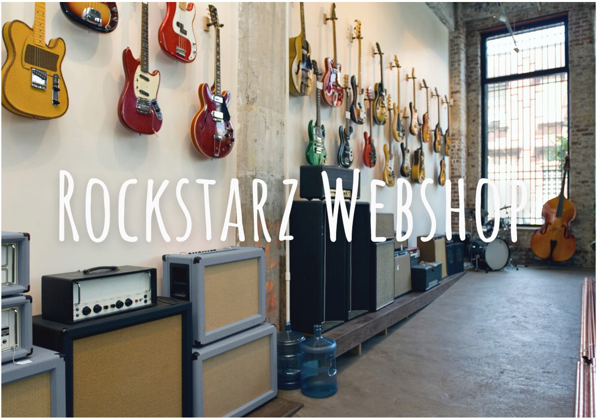 A music store with guitars hanging on the wall and amplifiers on the floor, in a bright room with large window and exposed brick wall. Webshop. online winkel Rockstarz Shop.  Gitaren, benodigdheden en informatie