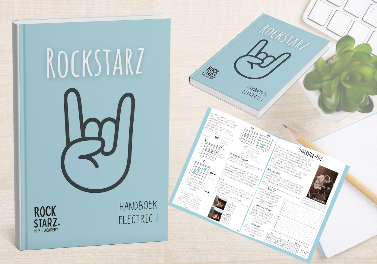 A light blue music book titled 'ROCKSTARZ' with a hand making the rock sign on the cover, placed on a wooden desk. Nearby is a smaller matching book, an open instructional booklet with music notation, a white keyboard, a pencil, and a potted succulent plant.