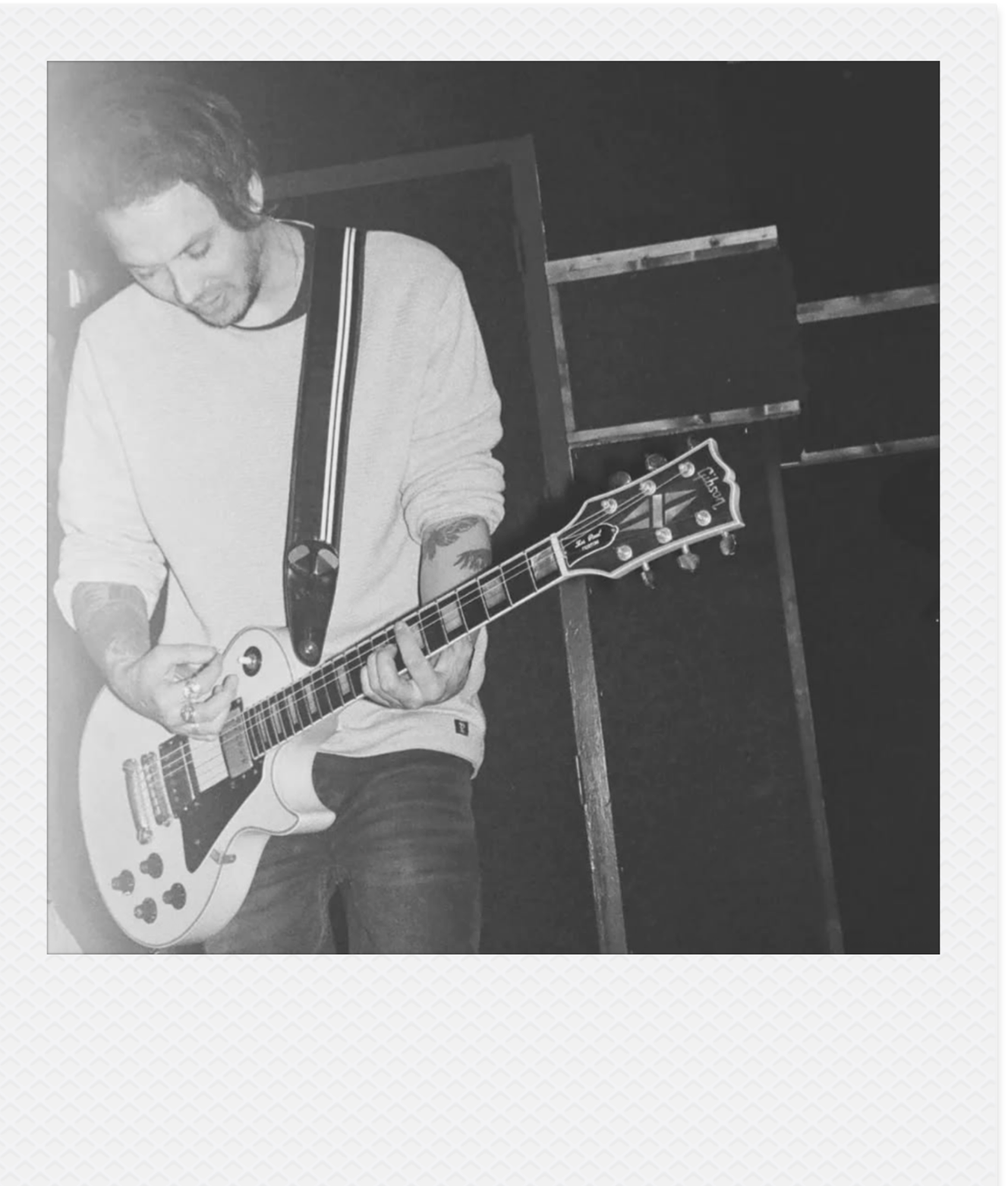 Zwart wit foto van een man die gitaar op het podium speelt. Legend