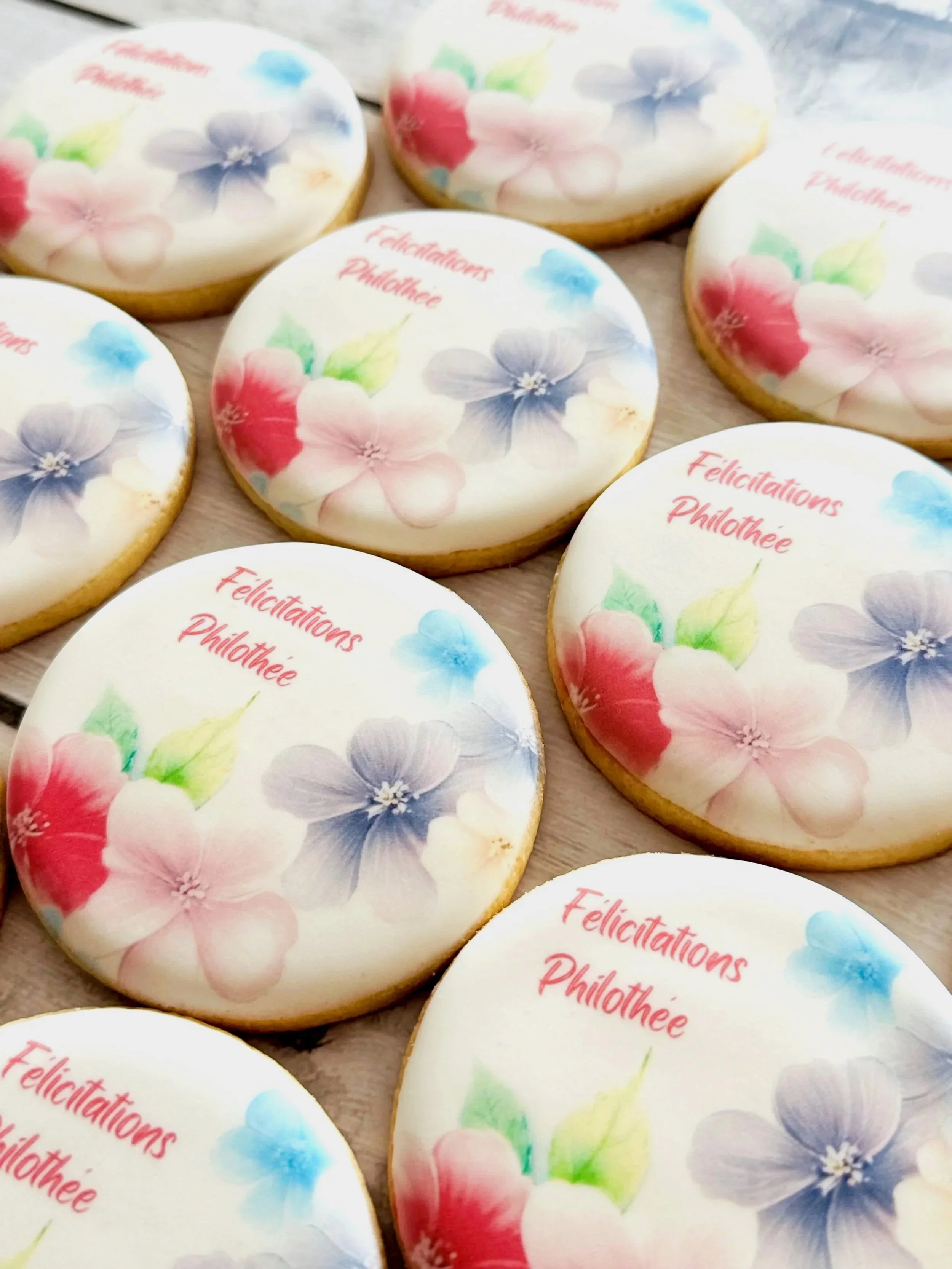 Decorated cookies with floral design and the message 'Félicitations Philothée.'