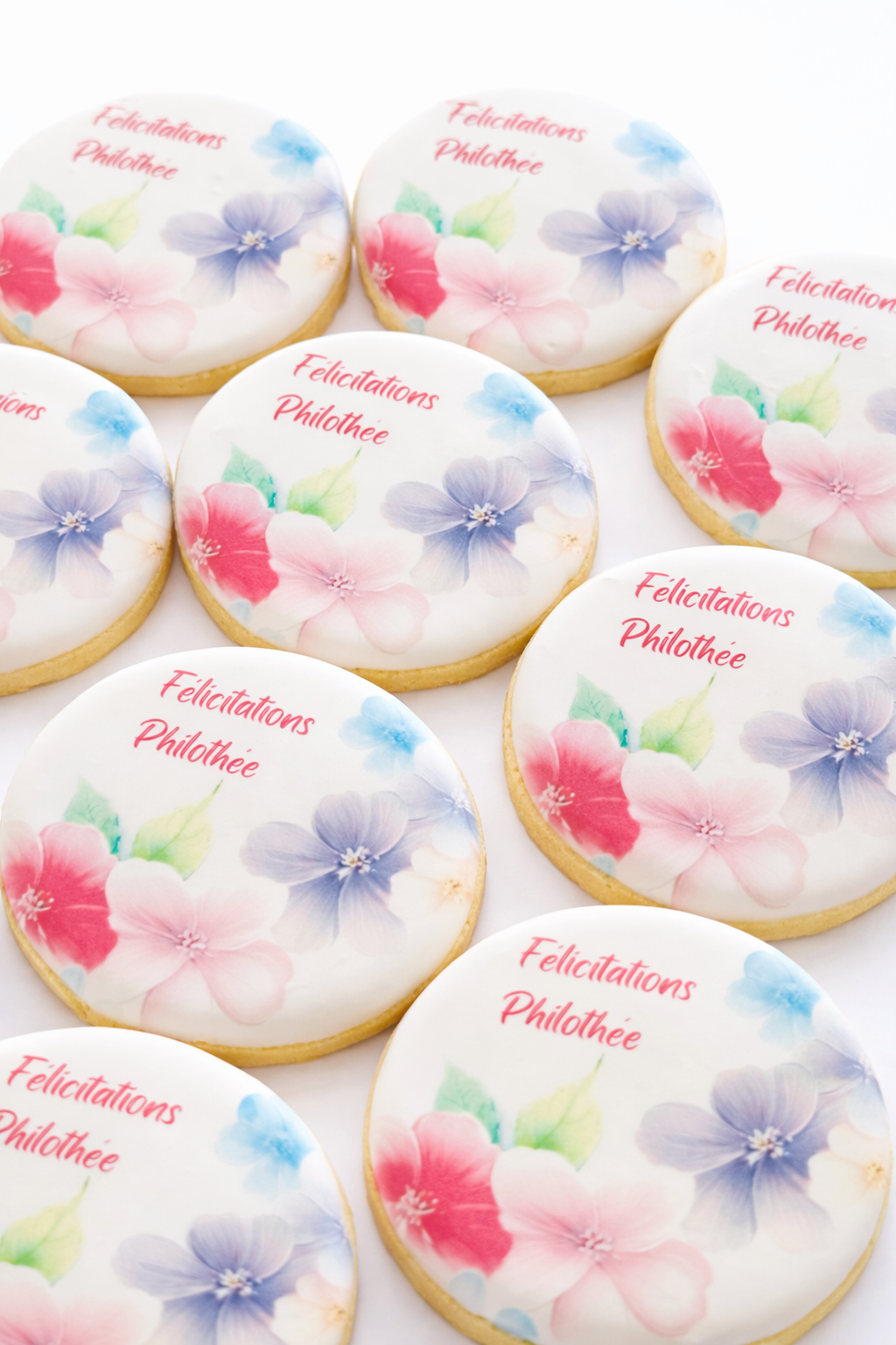 Decorated cookies with floral design and the message 'Félicitations Philothée.'