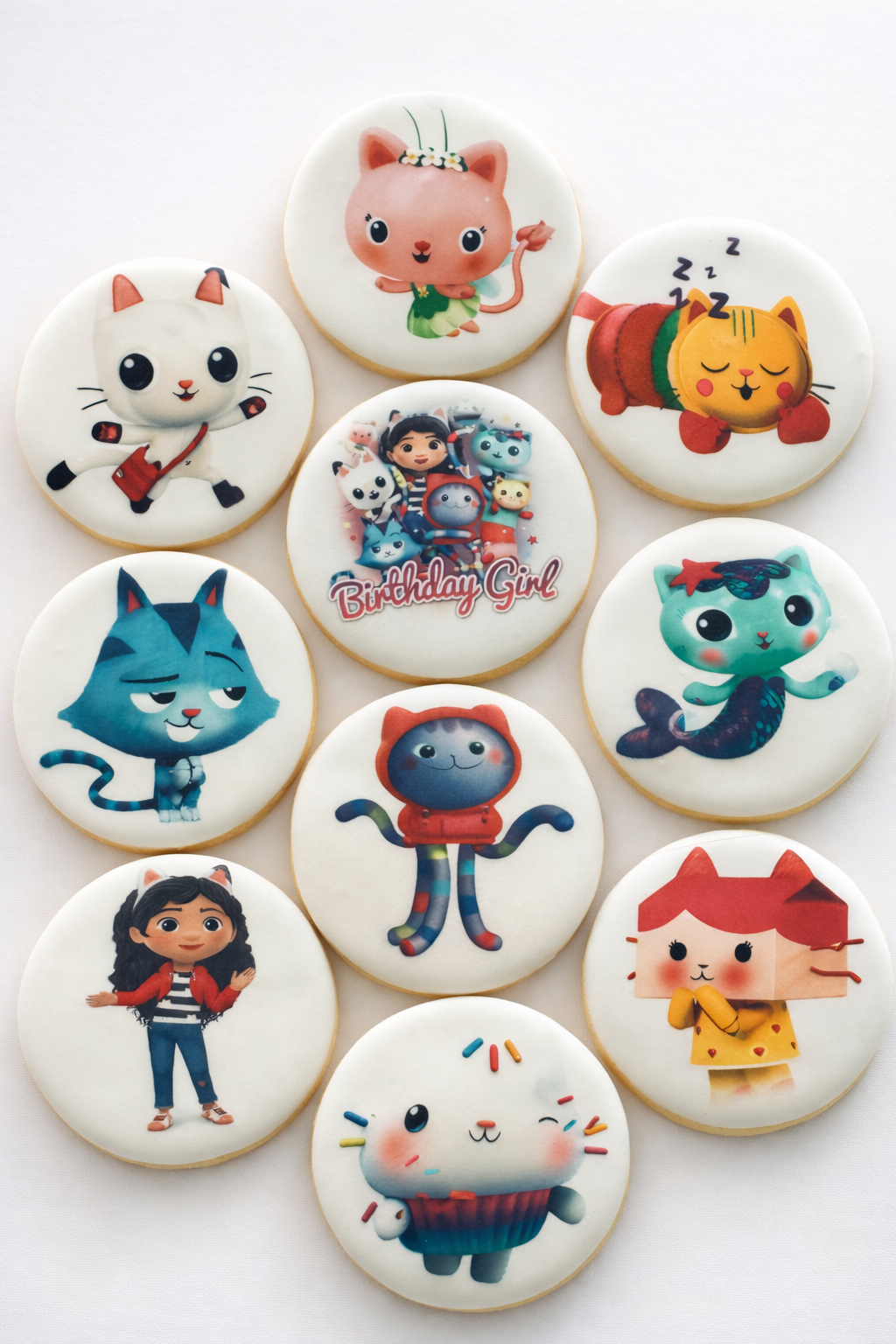 Decorative cookies with cartoon characters including cats, a girl, a mermaid, and a girl with pigtails, some with birthday themes.