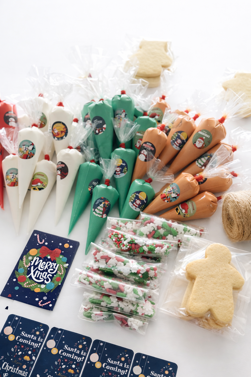 Assorted Christmas-themed cookies and candies, including colorful frosting cones, sugar cookies, and holiday stickers, displayed on a wooden surface.