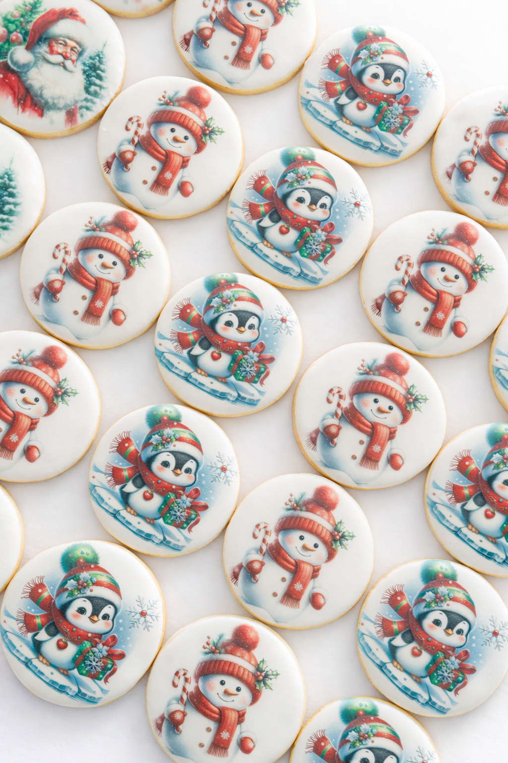 Collection of holiday cookies decorated with images of Santa Claus, snowmen, and penguins wearing winter hats and scarves, on a rustic wooden surface.