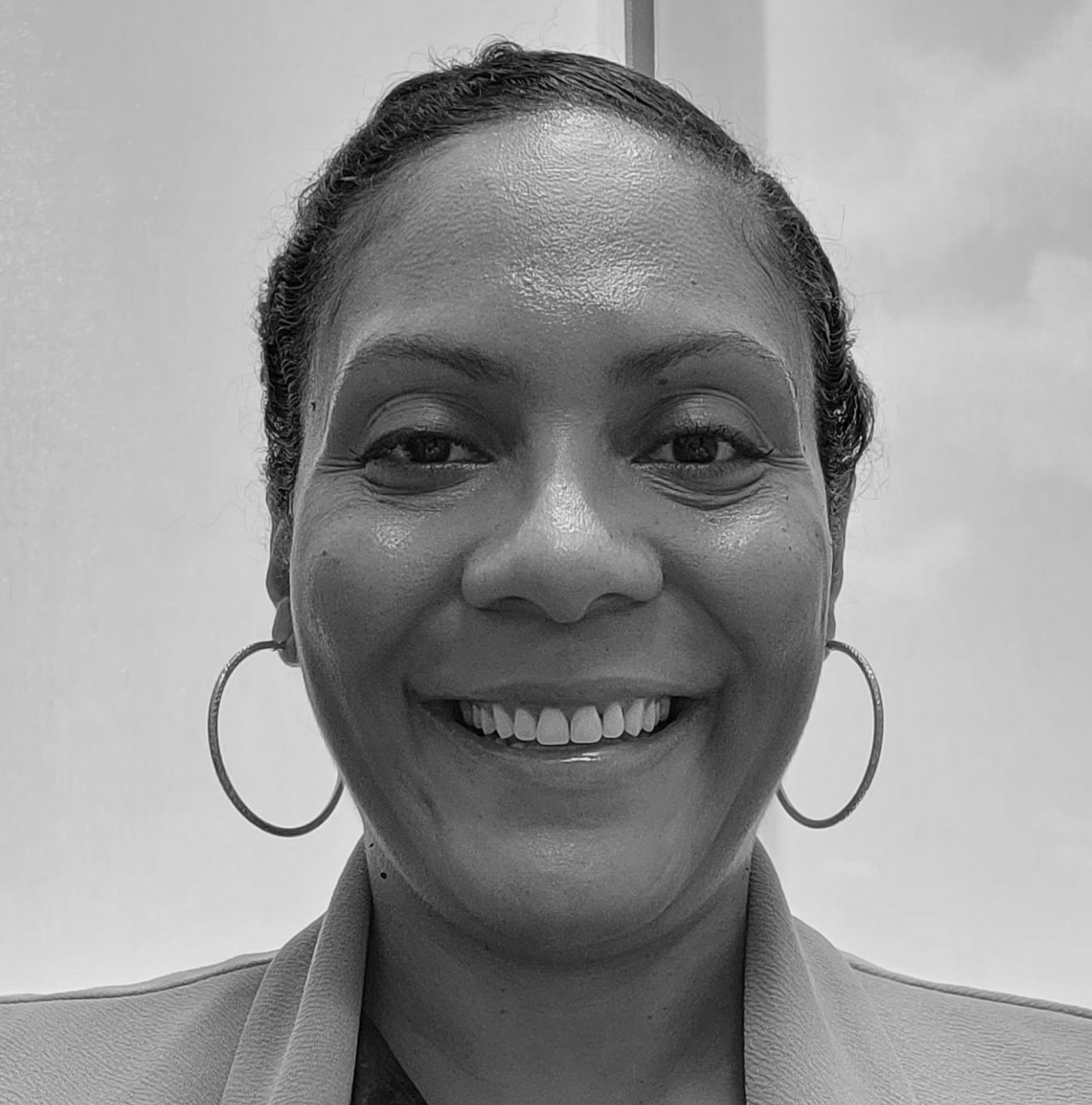 Black woman smiling, hoop earrings, short cropped hair