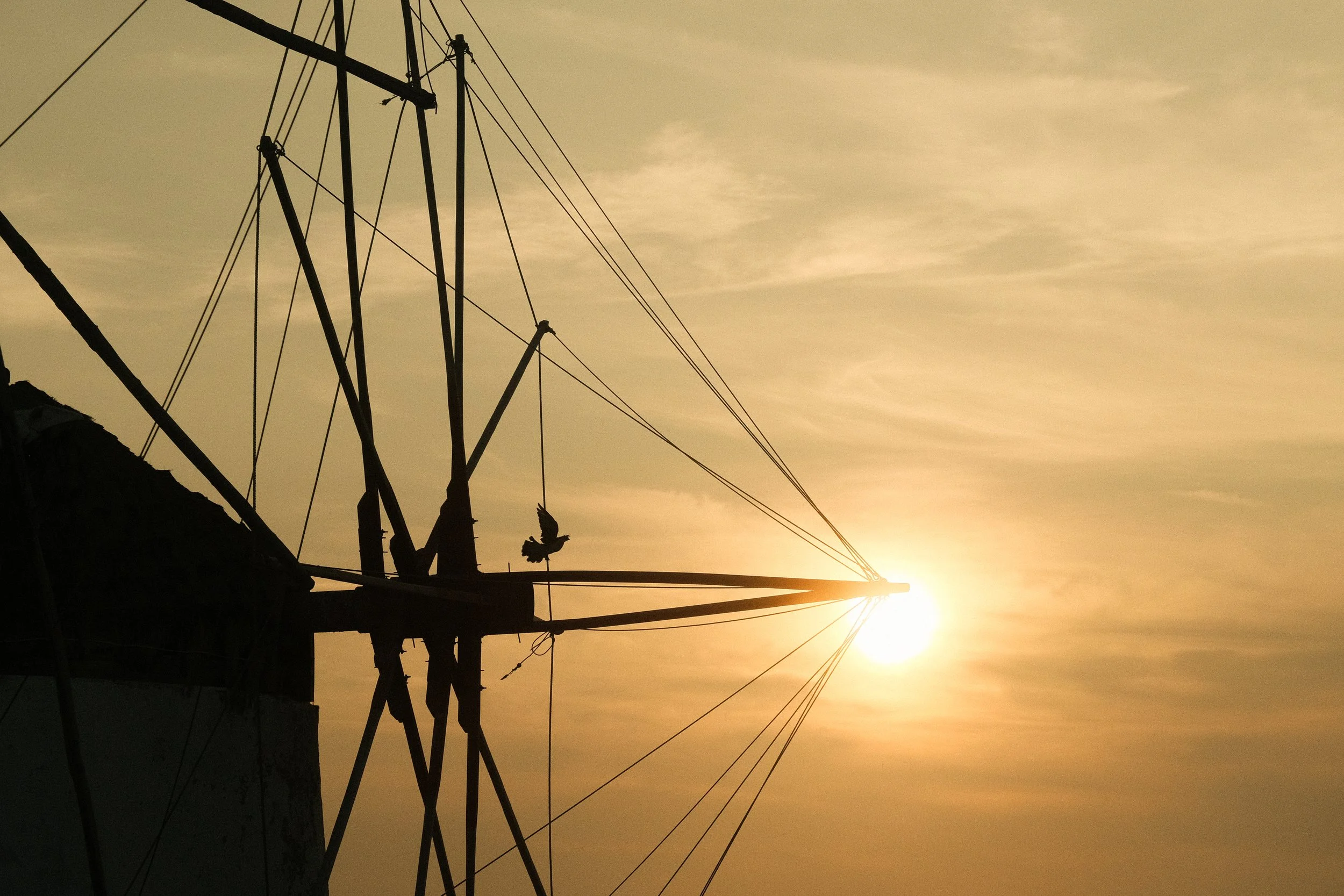 Silhouette eines alten Windjammers mit Segelmast vor Sonnenuntergang am Himmel.
