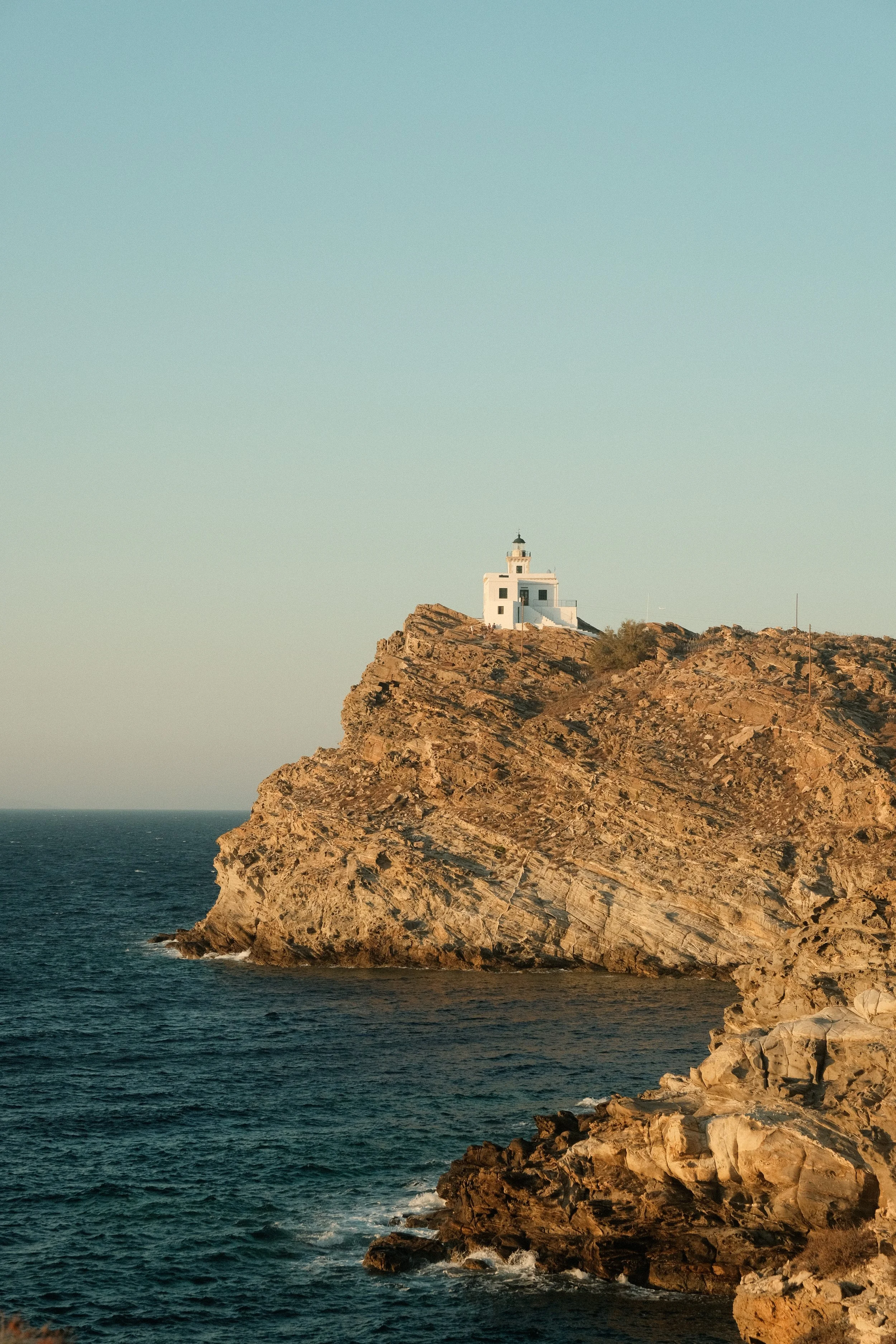 Leuchtturm auf einer Klippe am Meer bei Sonnenuntergang
