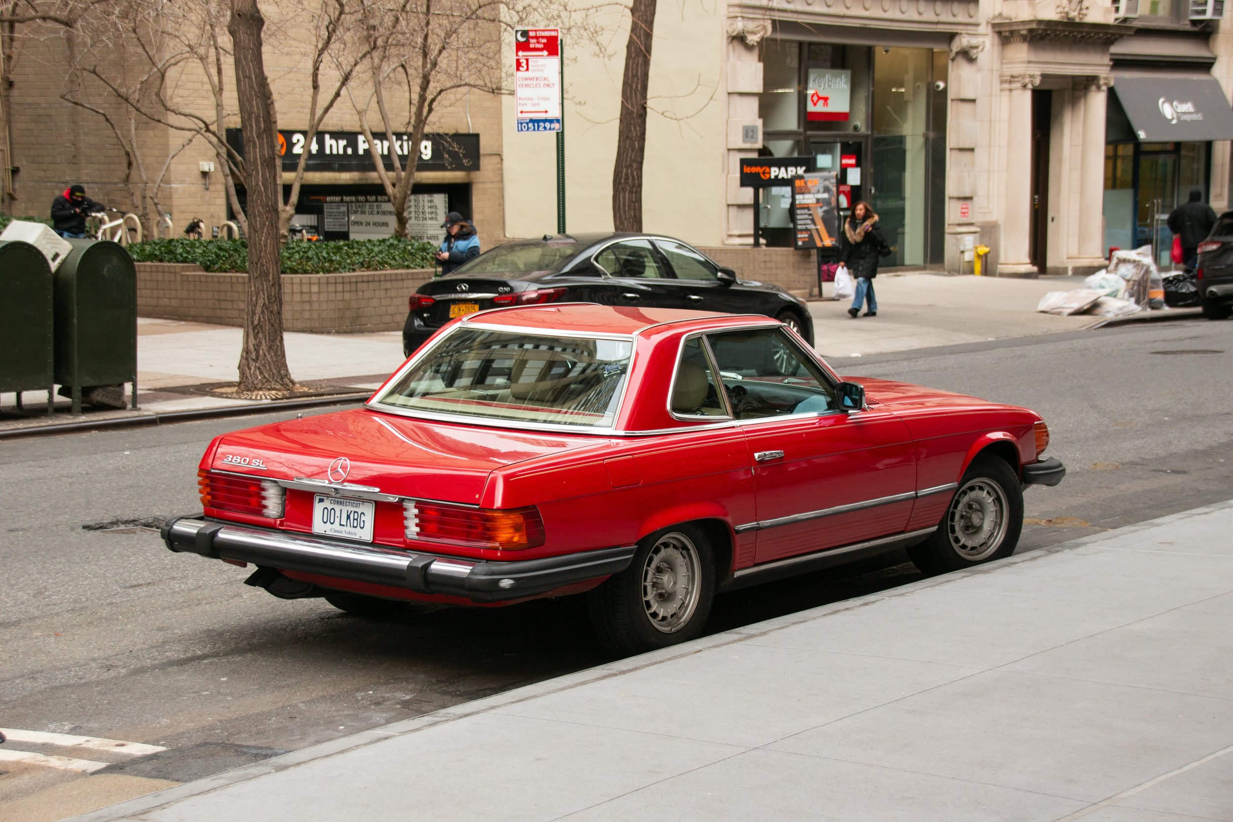 Ein rotes klassisches Mercedes-Benz Auto, Modell 380 SL, ist auf der Stadtstraße geparkt.