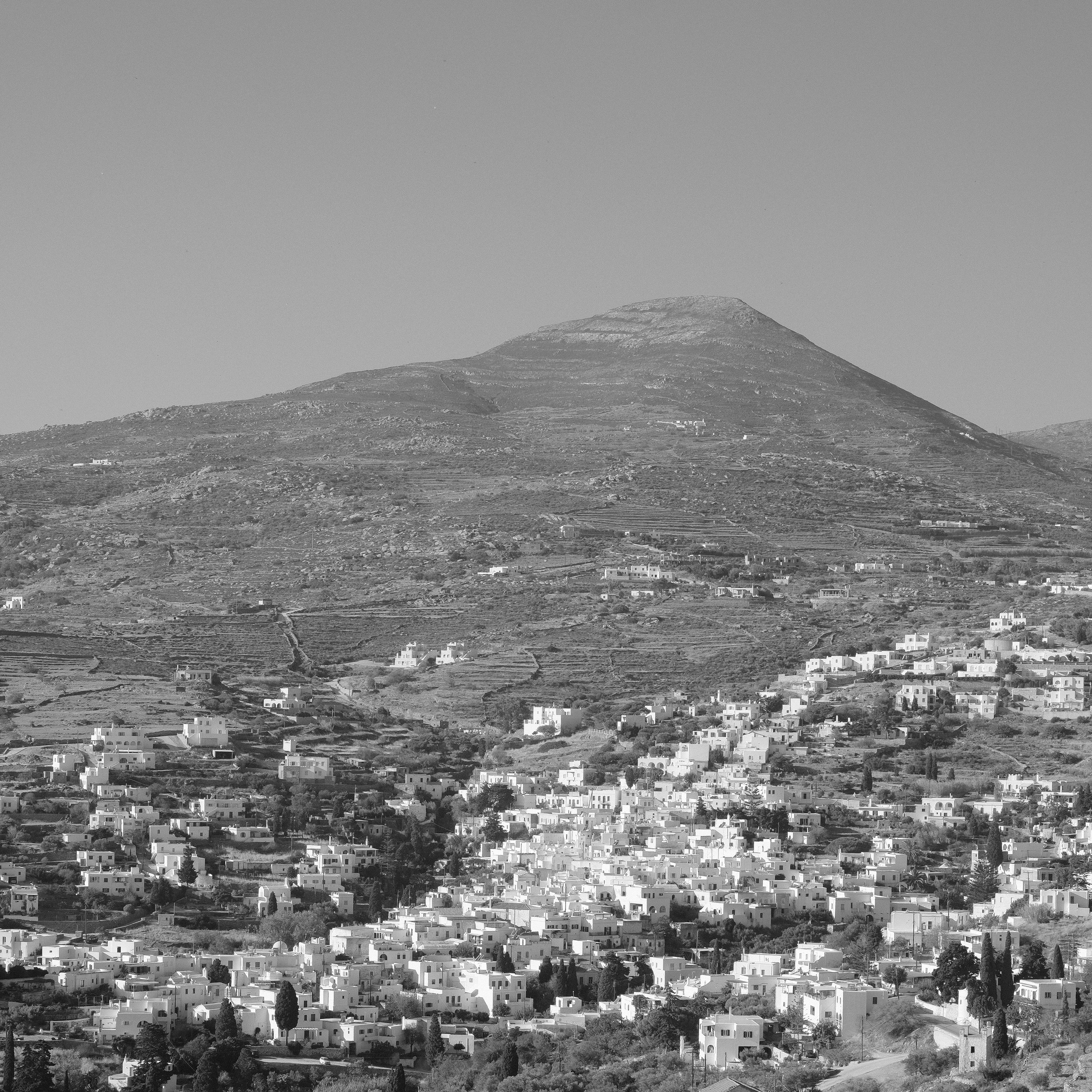Schwarz-Weiß-Bild eines Hügels mit zahlreichen weißen Gebäuden im Vordergrund.