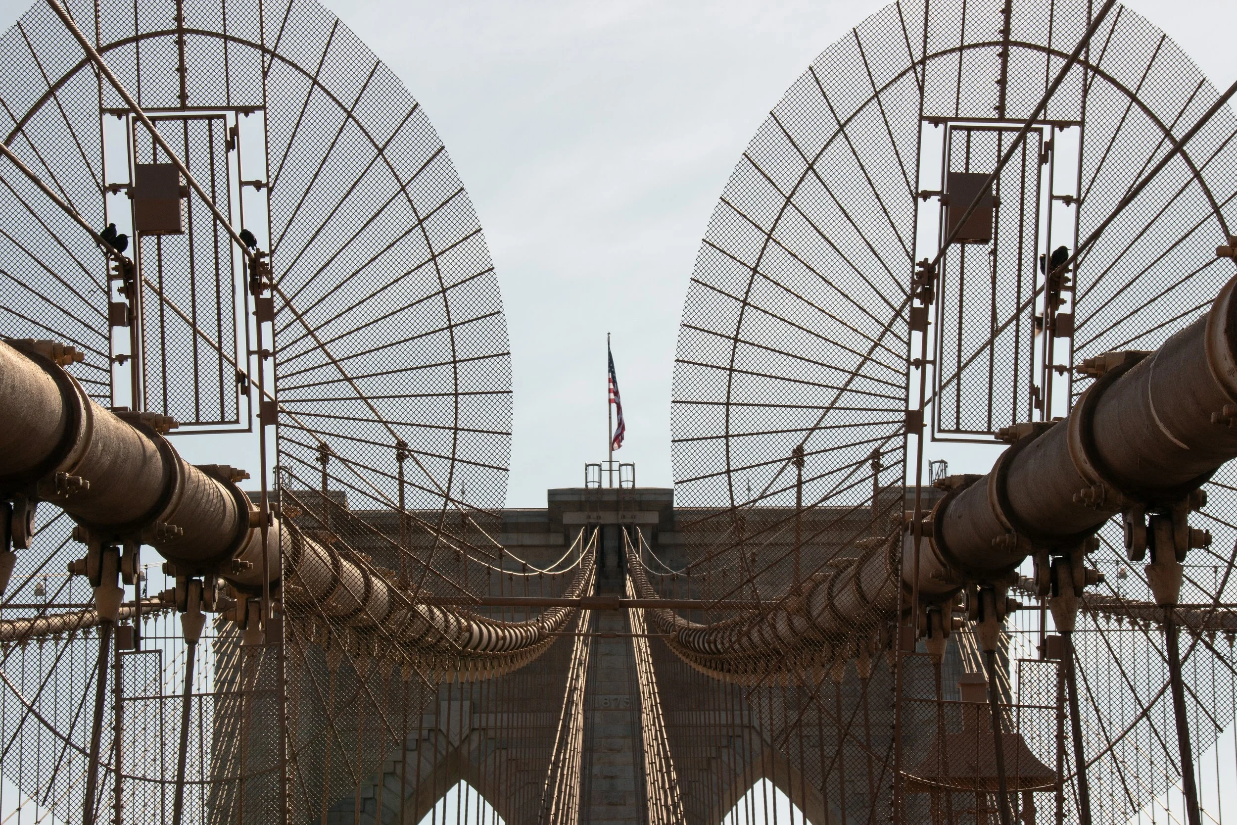 Untersuchung des Ausblicks auf die Brooklyn Bridge mit Blick auf das amerikanische Flaggen auf der Brücke.