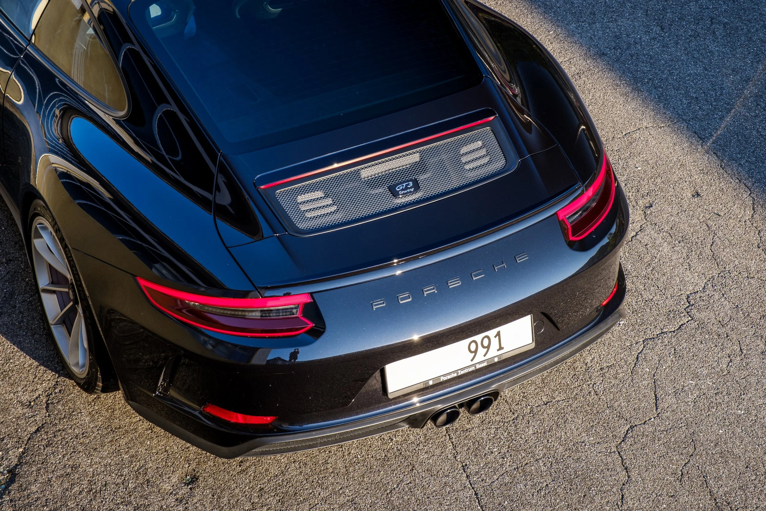 Schwarzer Porsche 911 GT3 von oben auf einer Straße fotografiert.