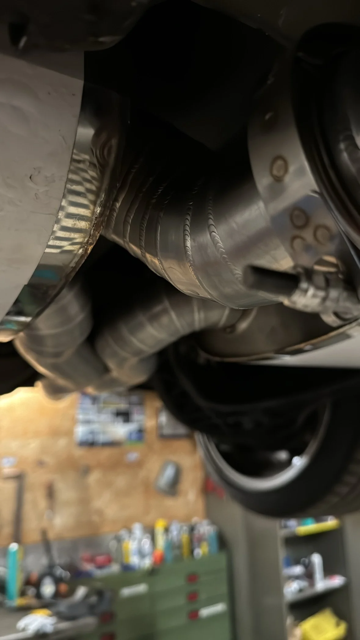 Nahaufnahme eines Fahrzeugauspuffs im Werkstatt-Umfeld.