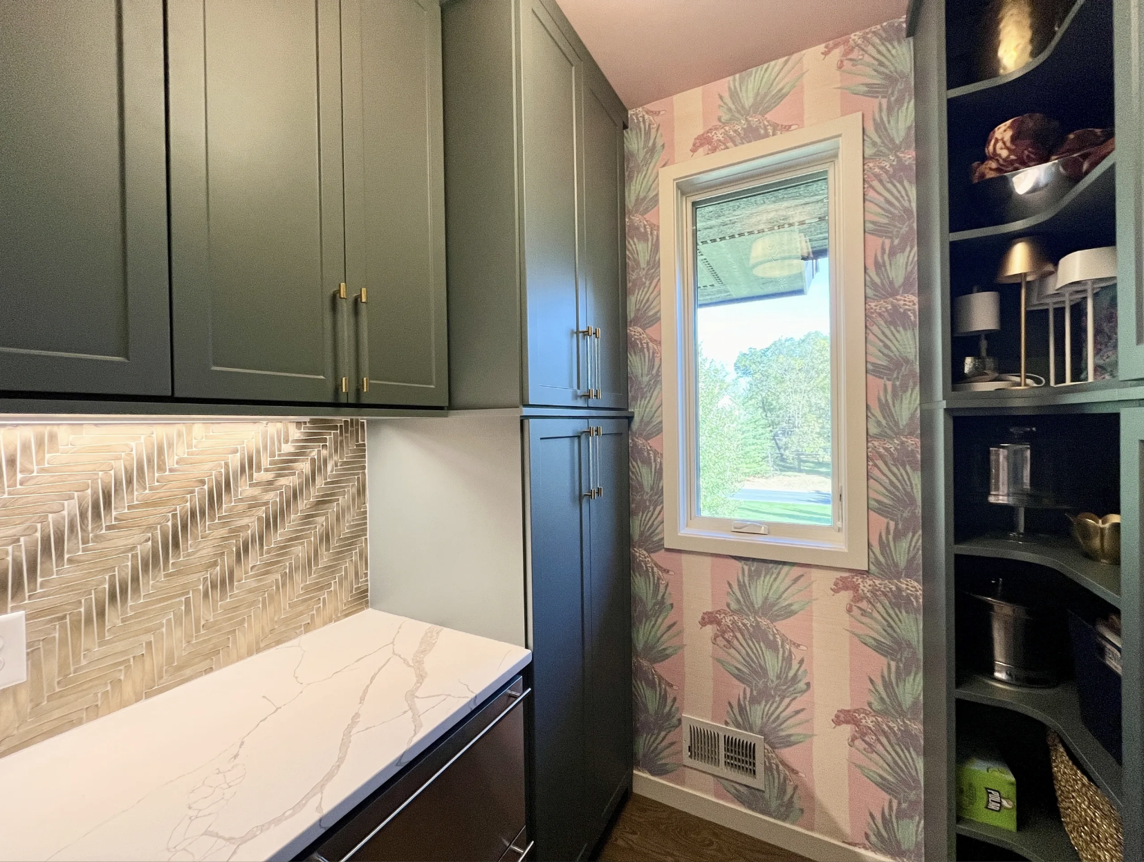 Modern kitchen featuring dark green painted cabinetry and decorative floral wallpaper installed by The List in Minneapolis.