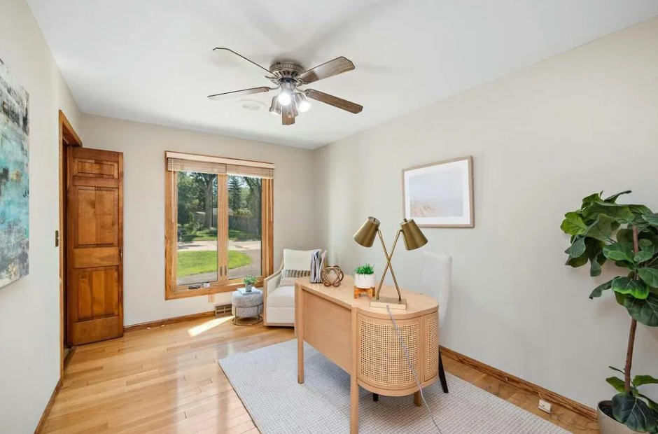 A bright, professionally painted home office with neutral walls, wood floors, and modern furniture, showcasing pre-listing painting results for realtors in Minneapolis.