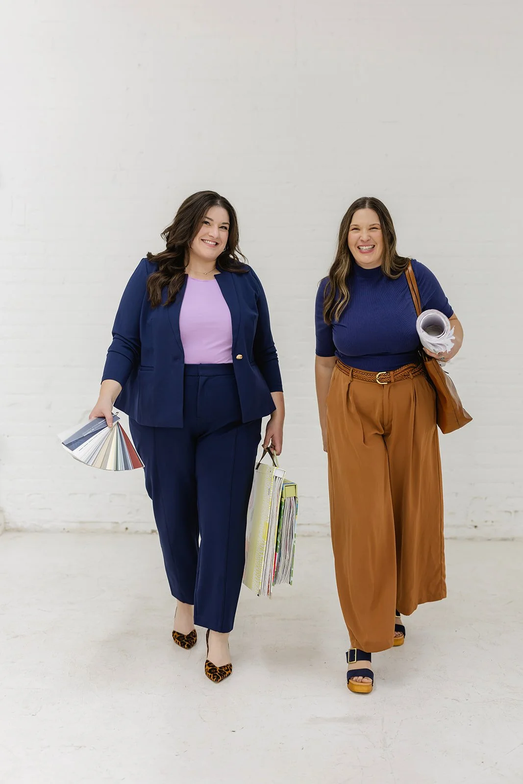 Founders of The List, a women-owned painting company in Minneapolis, MN, carrying paint supplies.