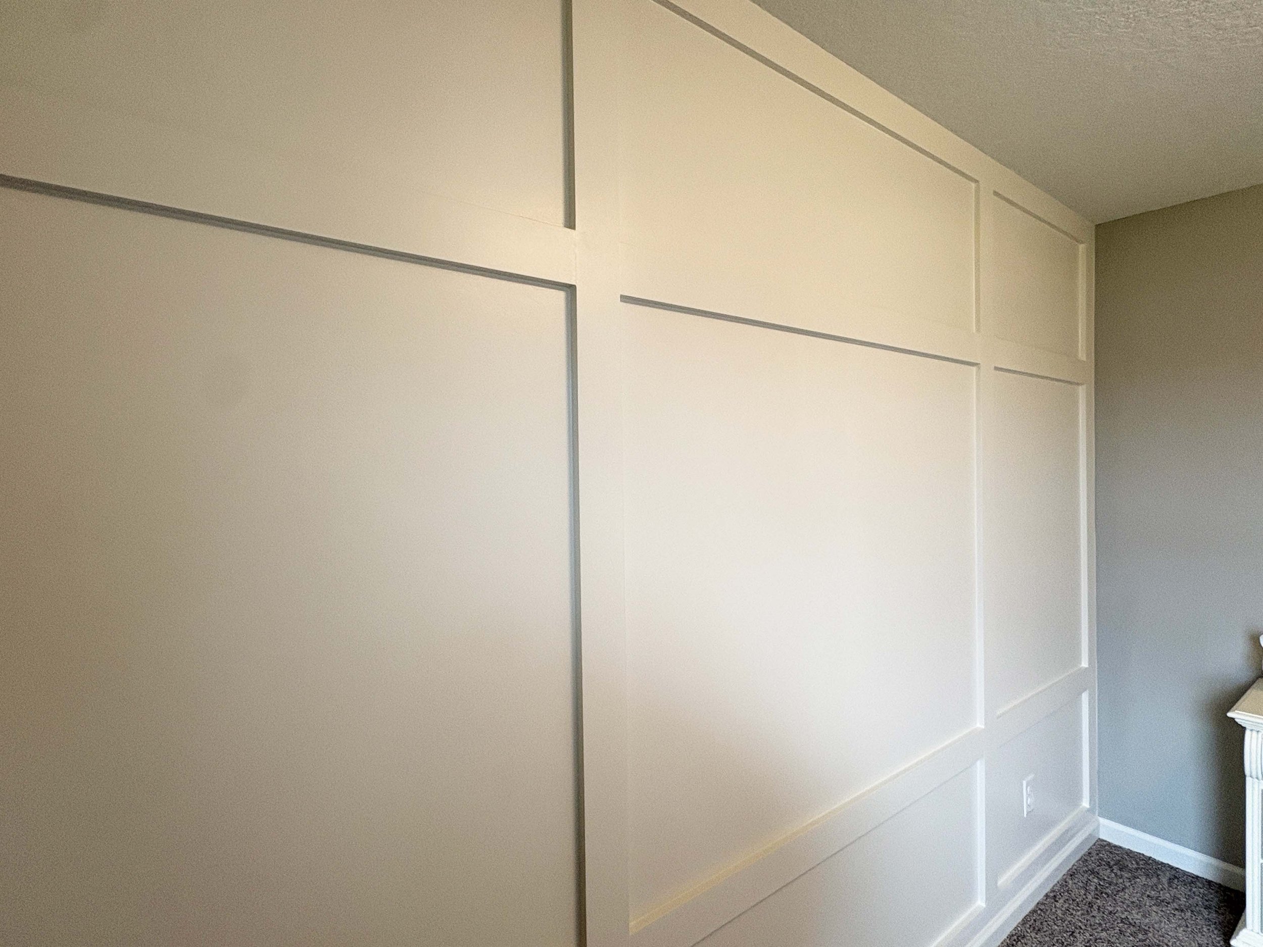 A custom cream-colored grid board and batten accent wall, showcasing expert carpentry and interior painting in MN.