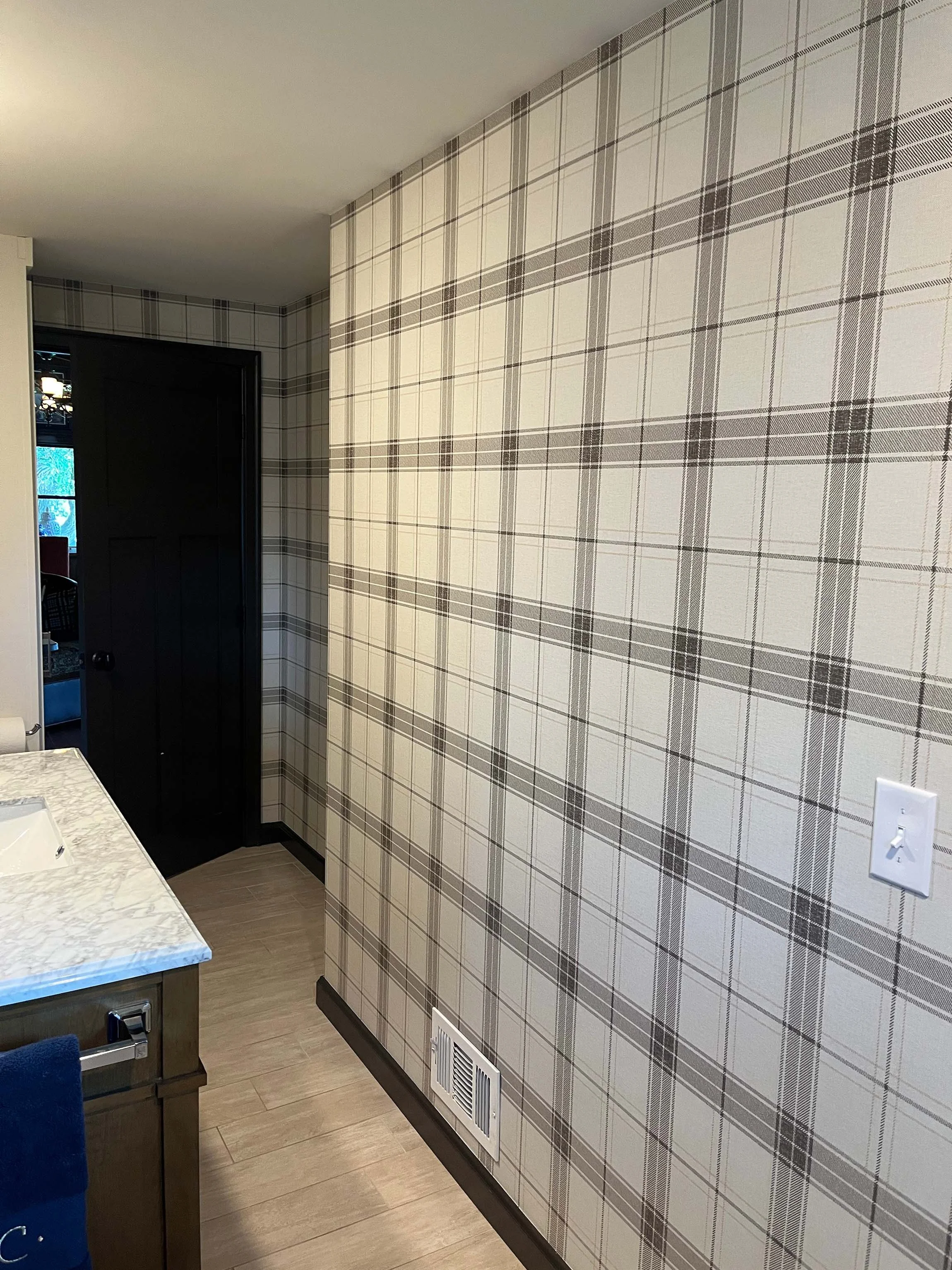 Close-up of a flawless plaid wallpaper installation in a custom residential bathroom.