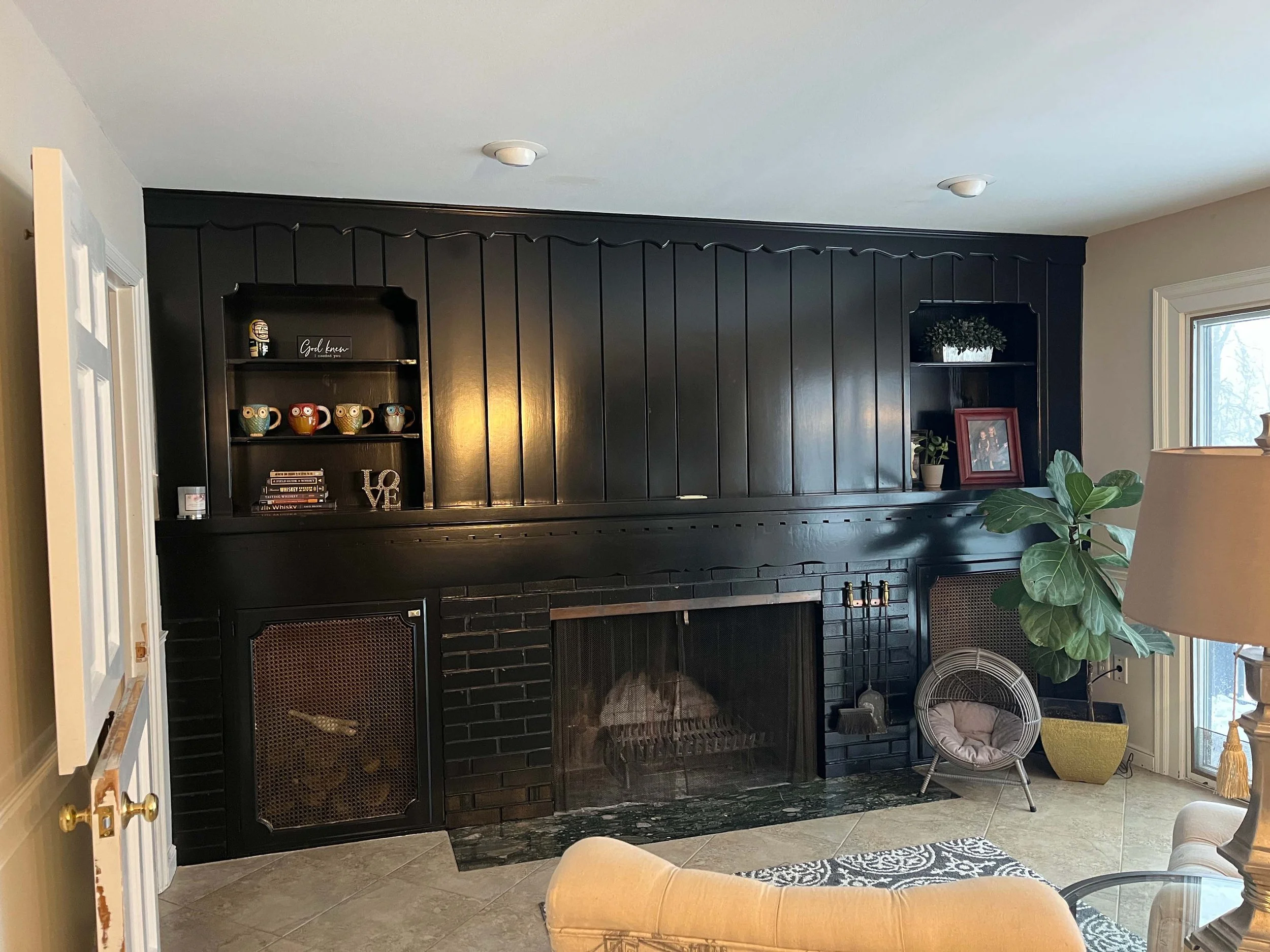 Striking living room focal point featuring a floor-to-ceiling black fireplace surround and coordinated custom wall finishes.