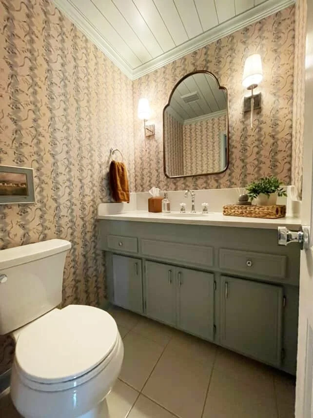 Professional bathroom renovation featuring a light blue painted vanity and floral wallpaper installation by The List in Minneapolis.