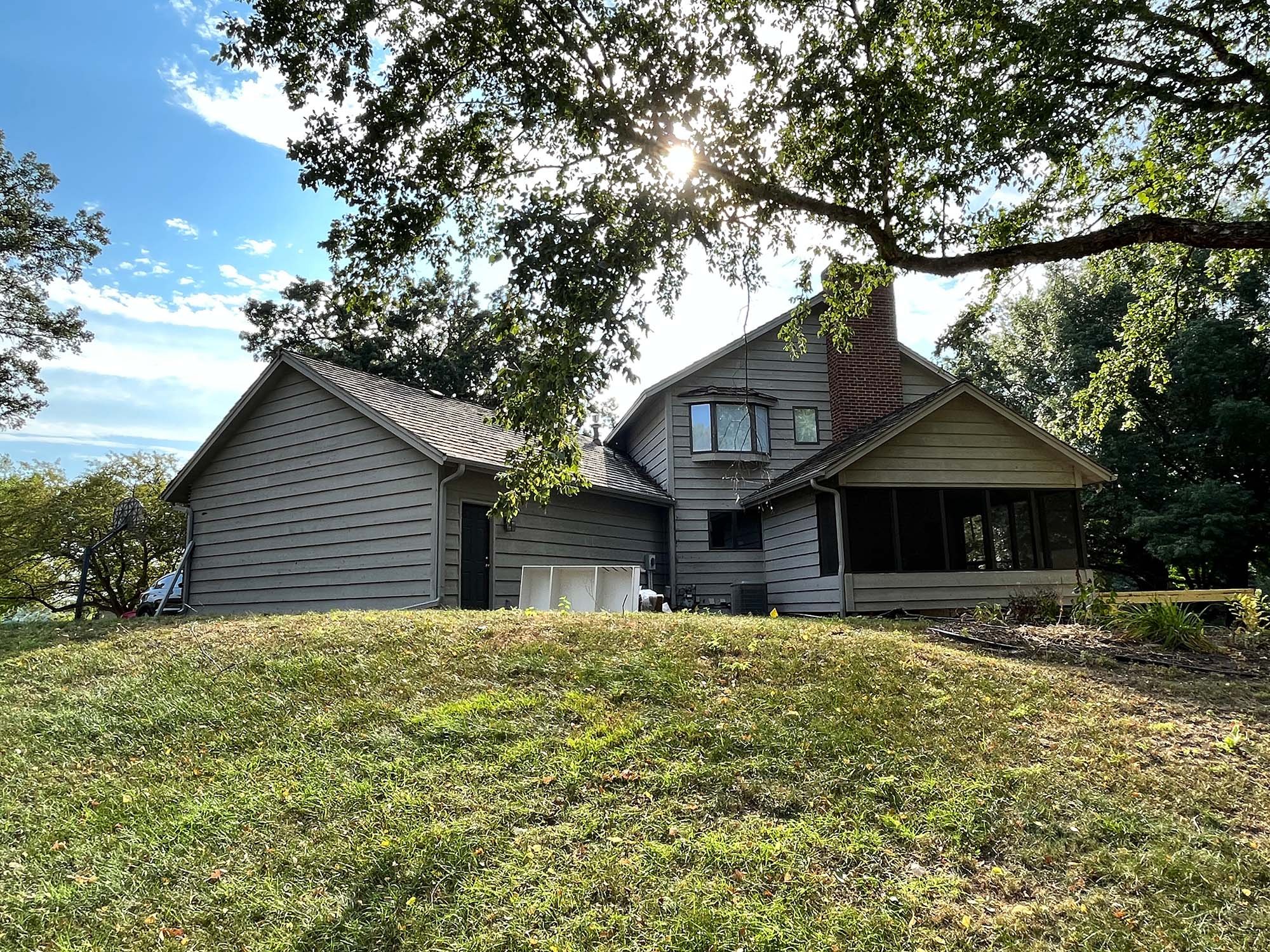 Gray house with screened in porch before exterior painting