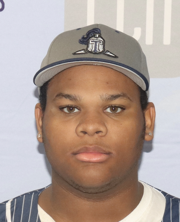Close-up of a young man wearing a grey sports cap and a pinstriped sports jersey, with a neutral expression.