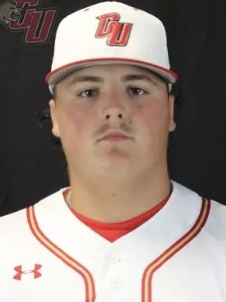 Young man in white baseball uniform and cap with red accents, featuring 'OU' logo, against a black background.