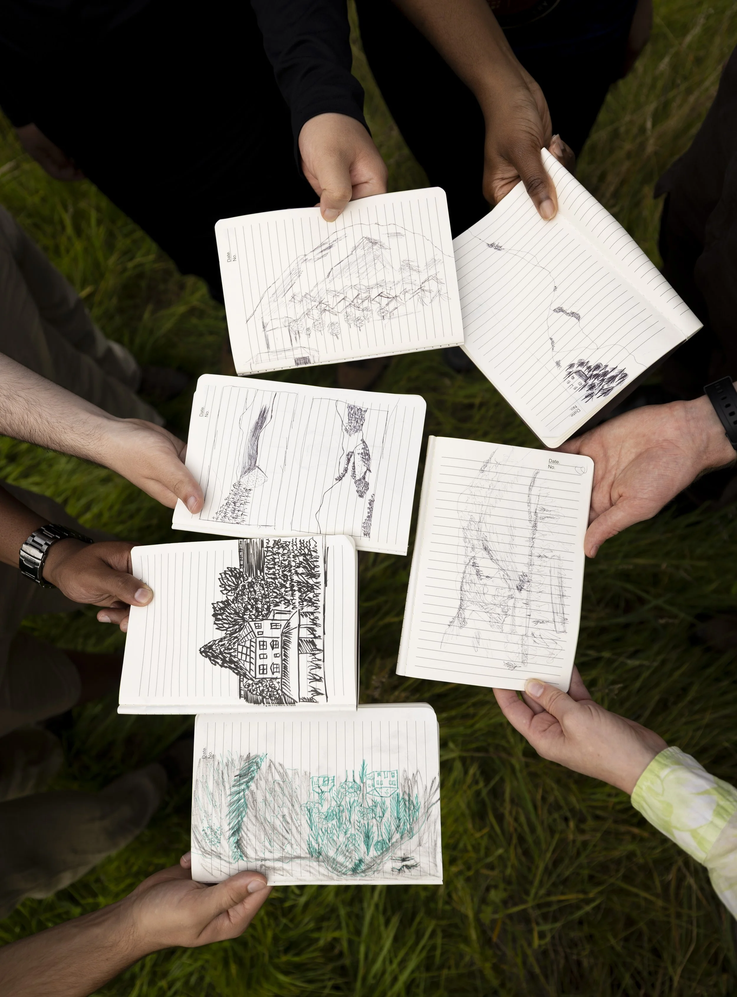 Group of ten diverse hikers standing outdoors in a lush, green landscape with rolling hills and fields in the background.