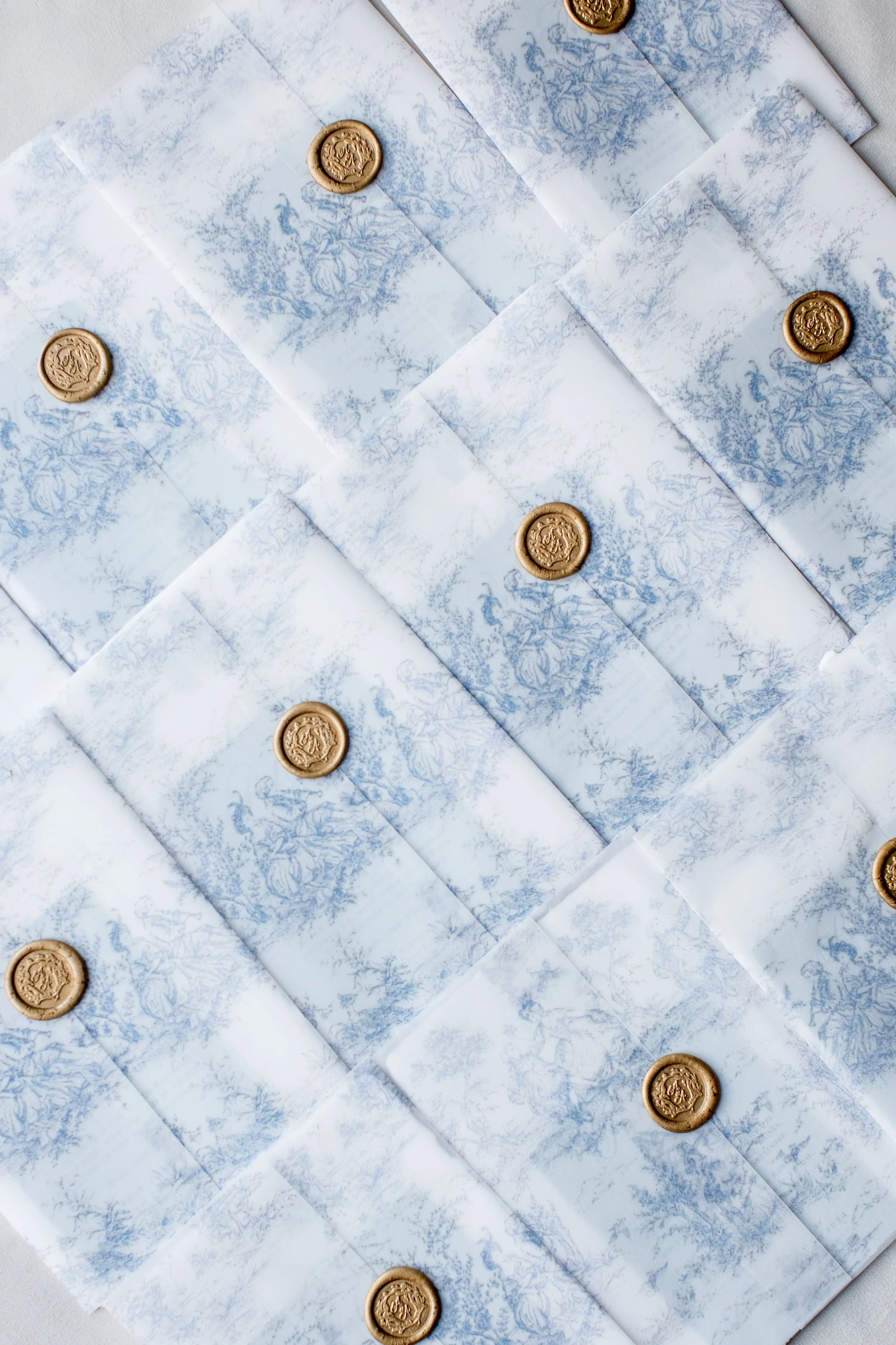 Multiple envelopes with blue and white fantasy landscape illustrations and gold wax seals.