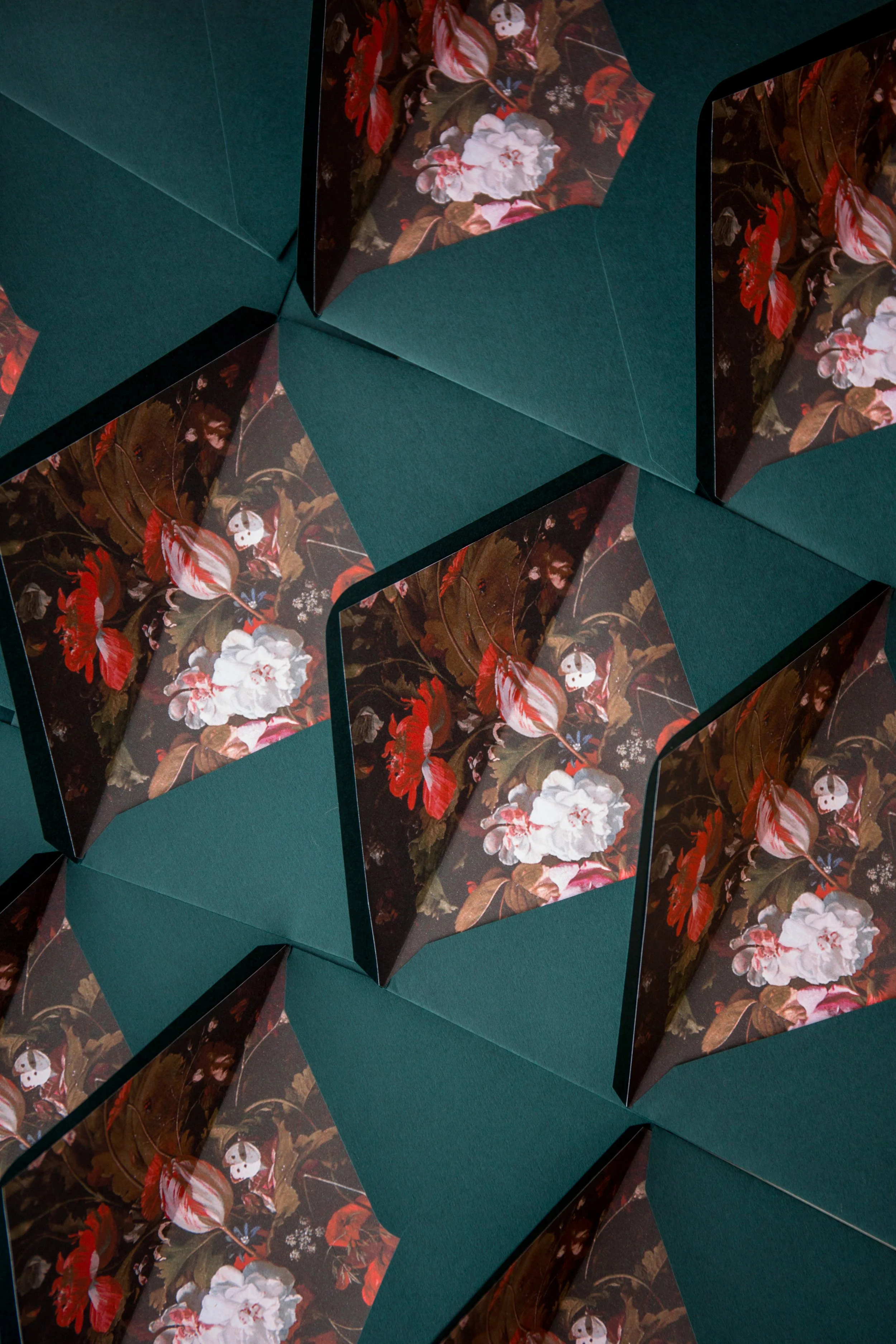 Multiple paper umbrellas with dark floral designs on green backgrounds.