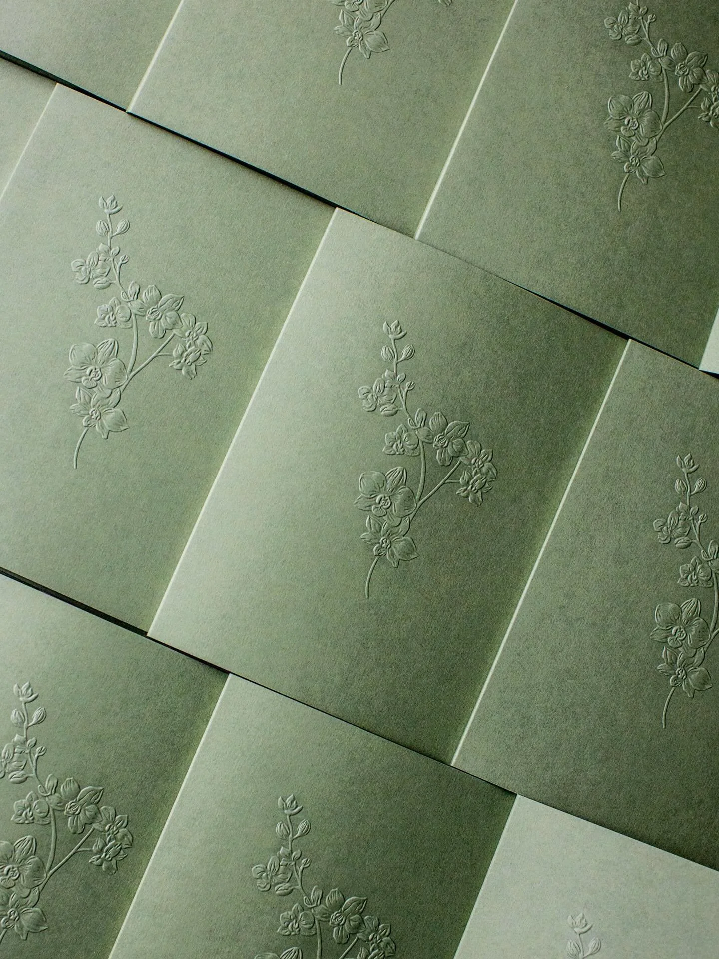 Much like a jacket finishes an outfit, an invitation deserves its own final layer.

Sculpted, embossed orchids (worn almost like a brooch I think) became the jacket for this suite, bringing together hand-illustrated details, a welcome card, and the a