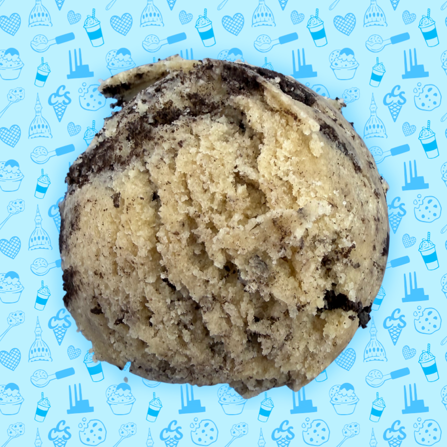 Cookies and cream cookie dough scoop with crushed chocolate cookie pieces on a blue Capital City Sweets patterned background.