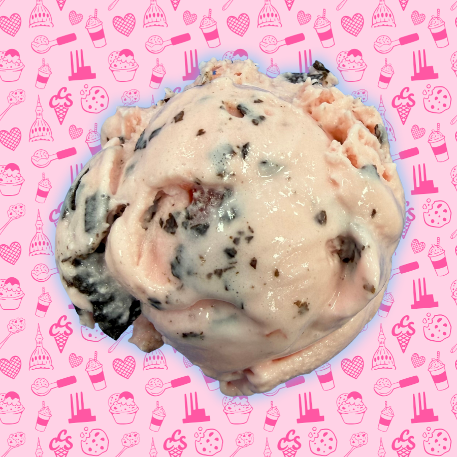 A scoop of amaretto cherry ice cream from Capital City Sweets, featuring a light pink base with visible cherry pieces and a smooth, creamy texture. This flavor blends sweet cherry with subtle almond notes for a rich, dessert-forward experience.